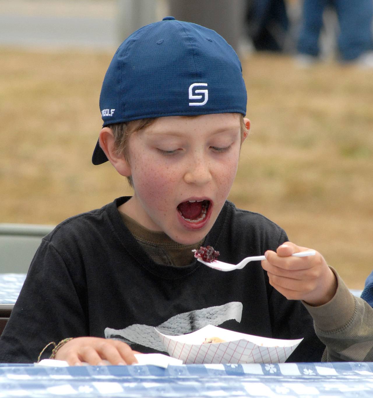 Max Vadset, 10, of Carlsborg opens wide for a bite of blackberry pie. (Keith Thorpe/Peninsula Daily News)