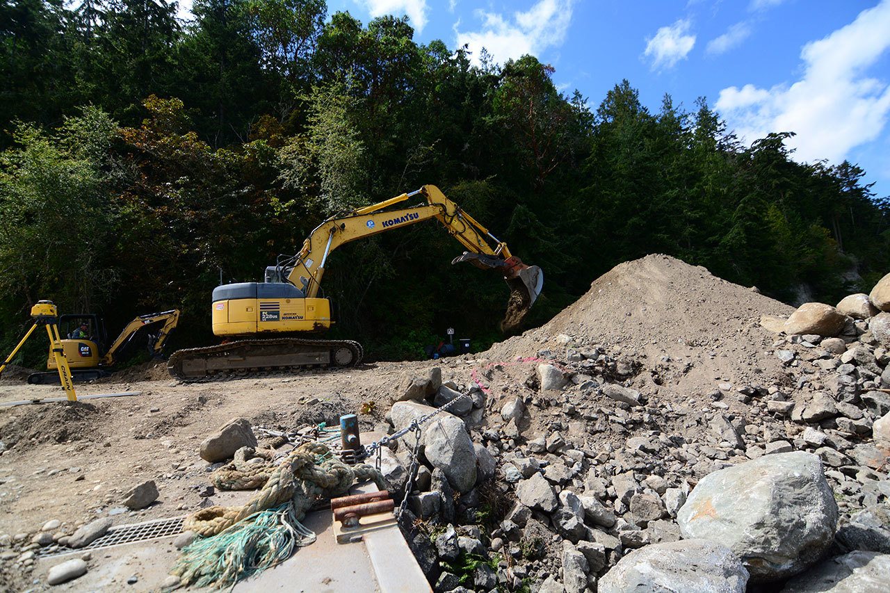 A backhoe works at regrading the soil and rocks as part of a shoreline restoration project at Fort Townsend State Park. (Jesse Major/Peninsula Daily News)