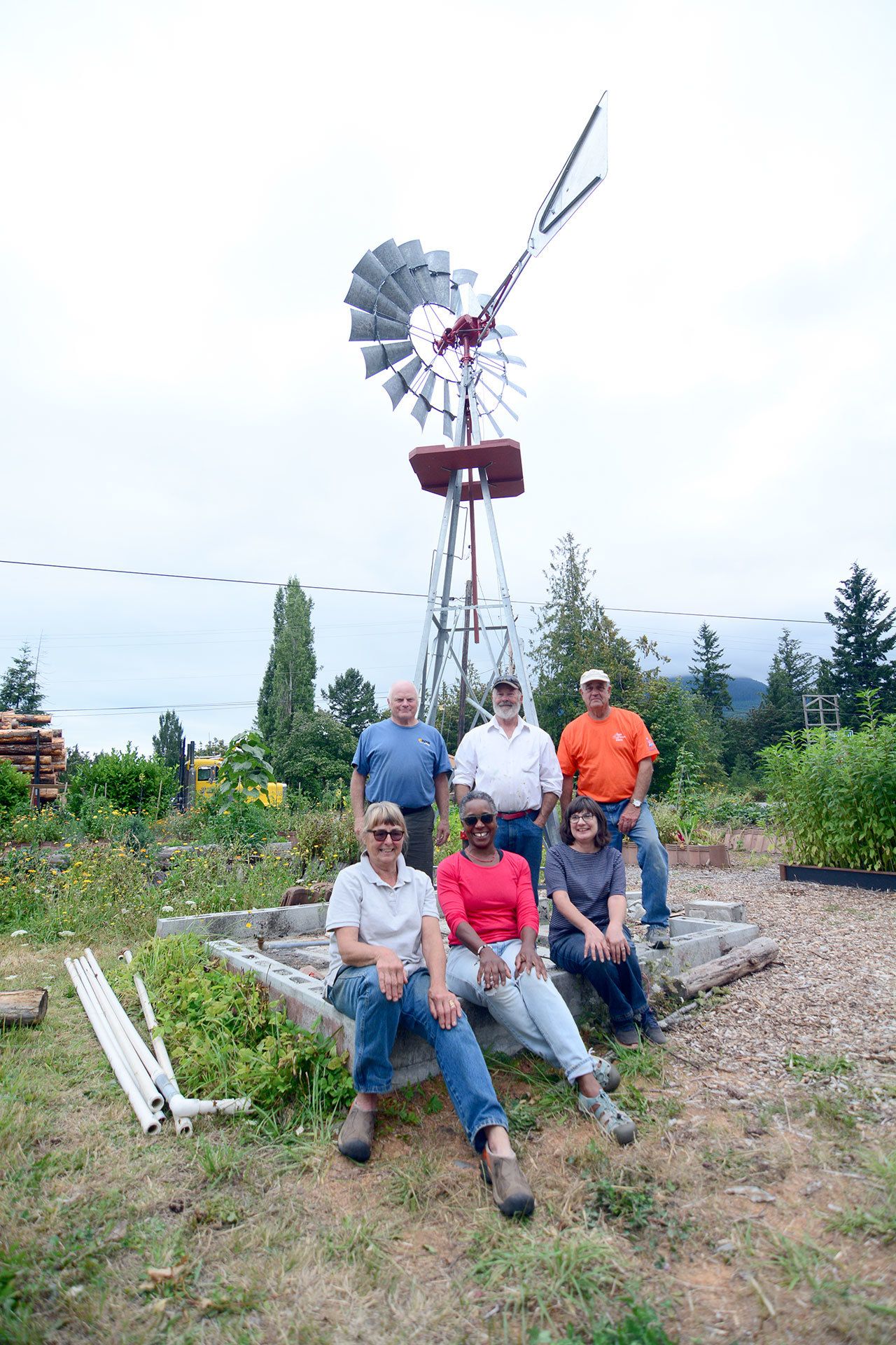 A windmill was erected Wednesday at Quilcene’s Q Gardens. In back, from left, are Bill Scott, Scott Abbott and Tim O’Neill. In front, from left, are Anne Ricker, Leslie Bunton and Juanita Thomas. (Jesse Major/Peninsula Daily News)