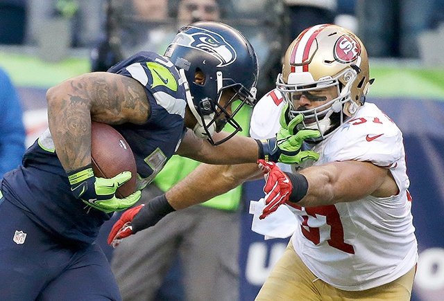 The Associated Press Seattle running back Thomas Rawls, left, pushes off San Francisco 49ers inside linebacker Michael Wilhoite, right, as he runs for a touchdown during the second half of an NFL football game, Sunday, Nov. 22, 2015, in Seattle.