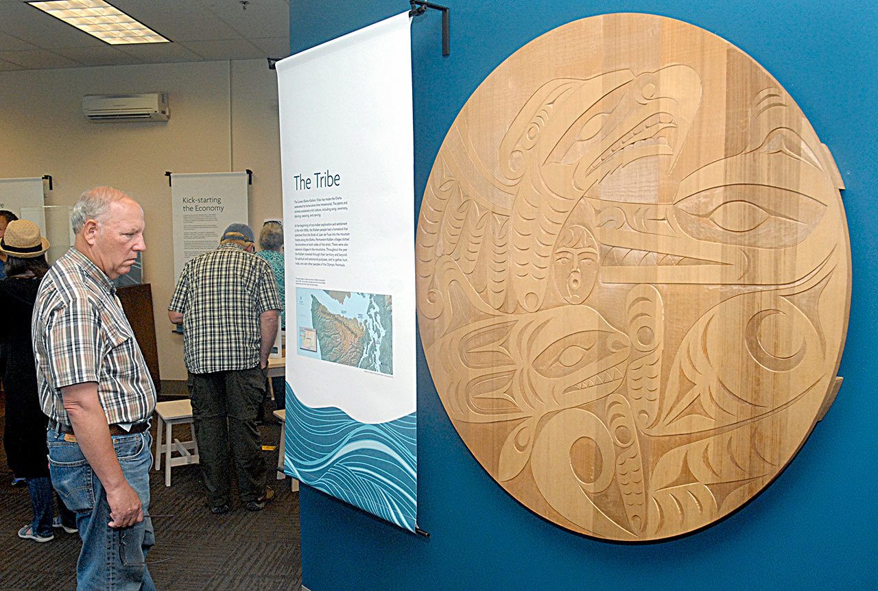 Paul Howard of Port Angeles examines a spiral wheel created by Lower Elwha Klallam tribal members Alfred Charles Jr. and Darrell Charles Jr. depicting a part of Klallam culture as part of a newly opened Elwha River and dam removal exhibit at the Elwha Klallam Heritage Center in Port Angeles. (Keith Thorpe/Peninsula Daily News)                                Paul Howard of Port Angeles examines a spiral wheel created by Lower Elwha Klallam tribal members Alfred Charles Jr. and Darrell Charles Jr. depicting a part of Klallam culture as part of a newly opened Elwha River and dam removal exhibit at the Elwha Klallam Heritage Center in Port Angeles. (Keith Thorpe/Peninsula Daily News)
