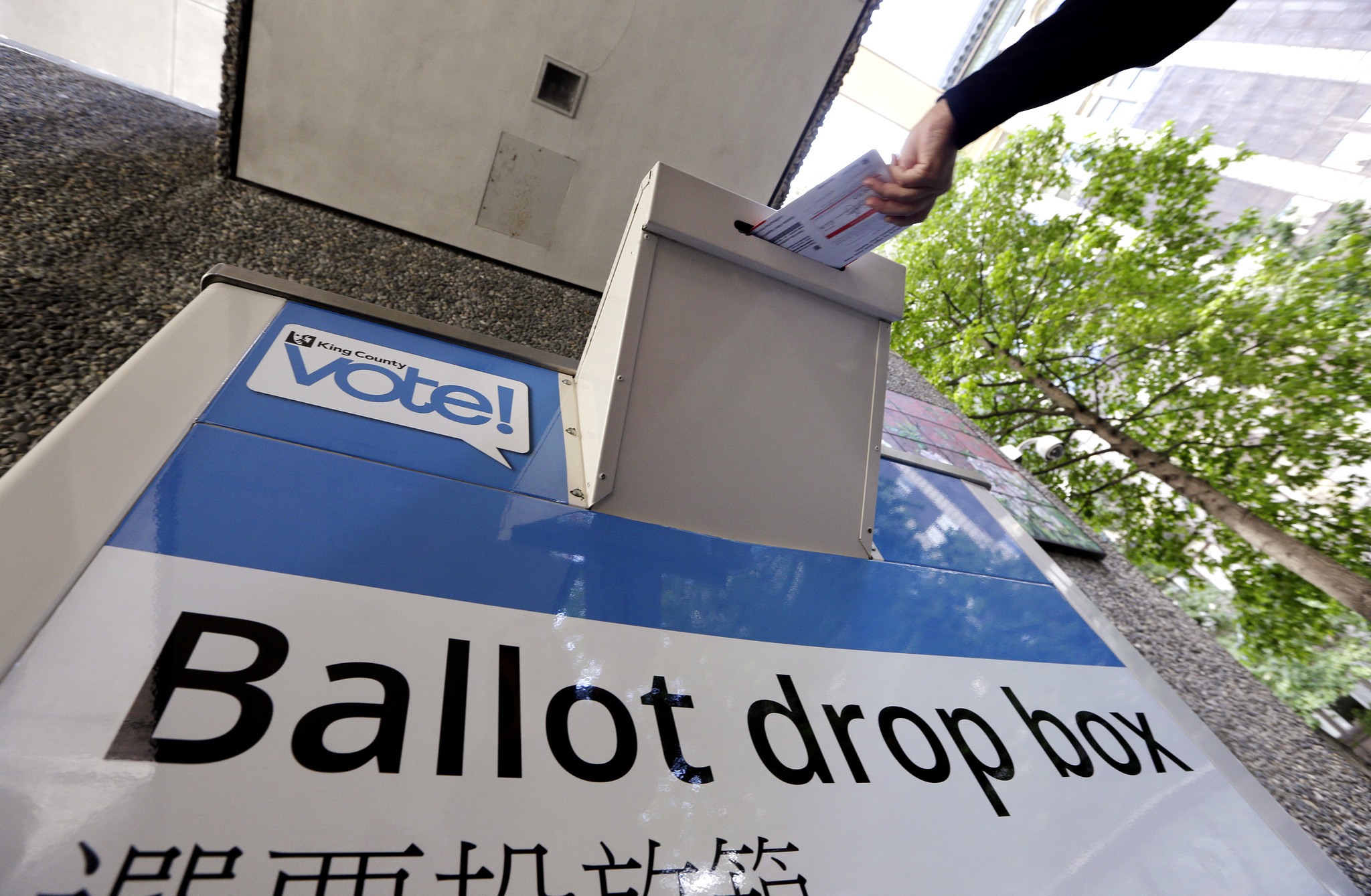 A voter drops a ballot into a ballot drop box Tuesday in Seattle. (AP Photo/Elaine Thompson)