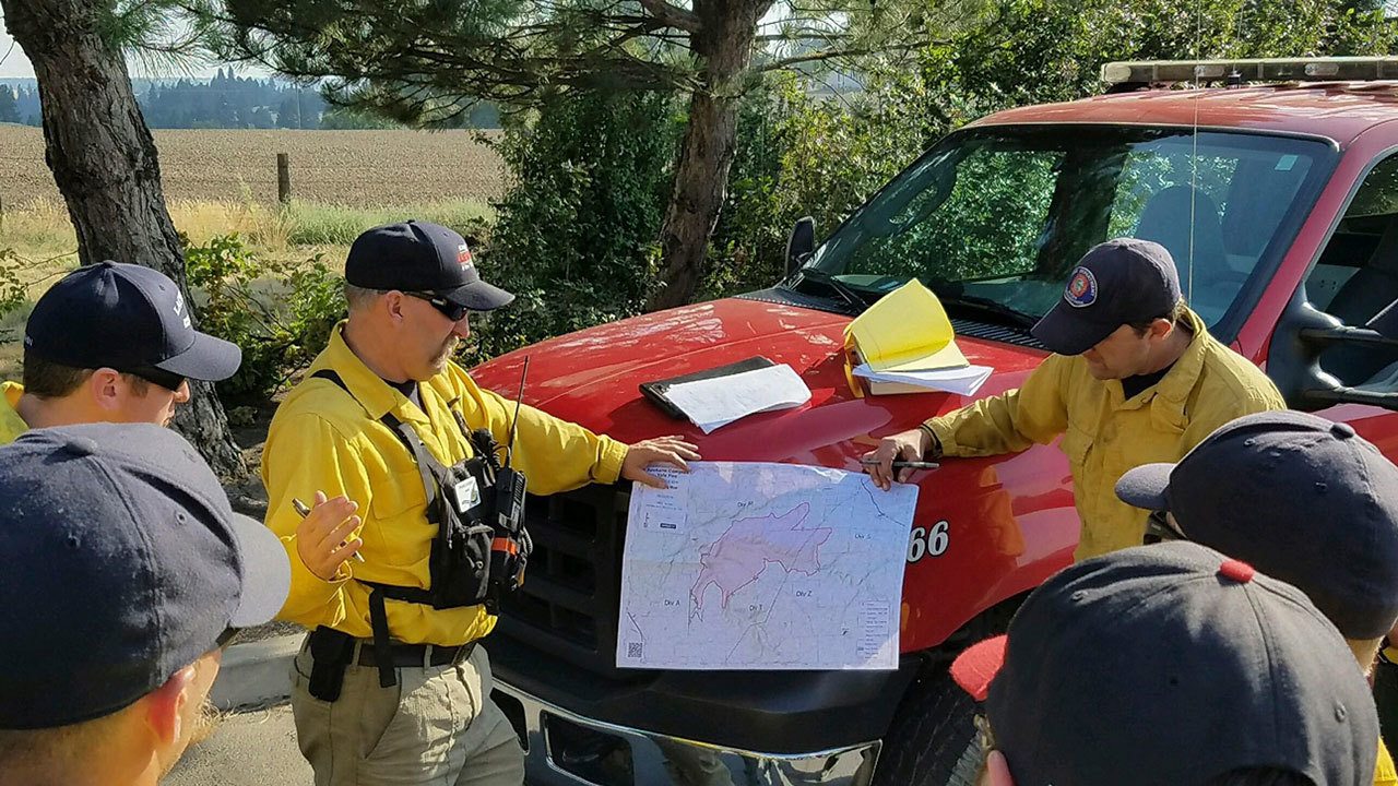 Clallam County Fire District No. 2 firefighters receive a briefing on their shift assignment at the Yale Road Fire southeast of Spokane. (Steve Bentley/Clallam County Fire District No. 2)