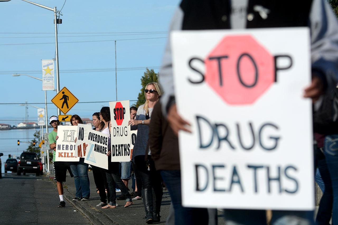 A crowd displays signs toward the street before the overdose awareness walk Tuesday afternoon. (Jesse Major/Peninsula Daily News)