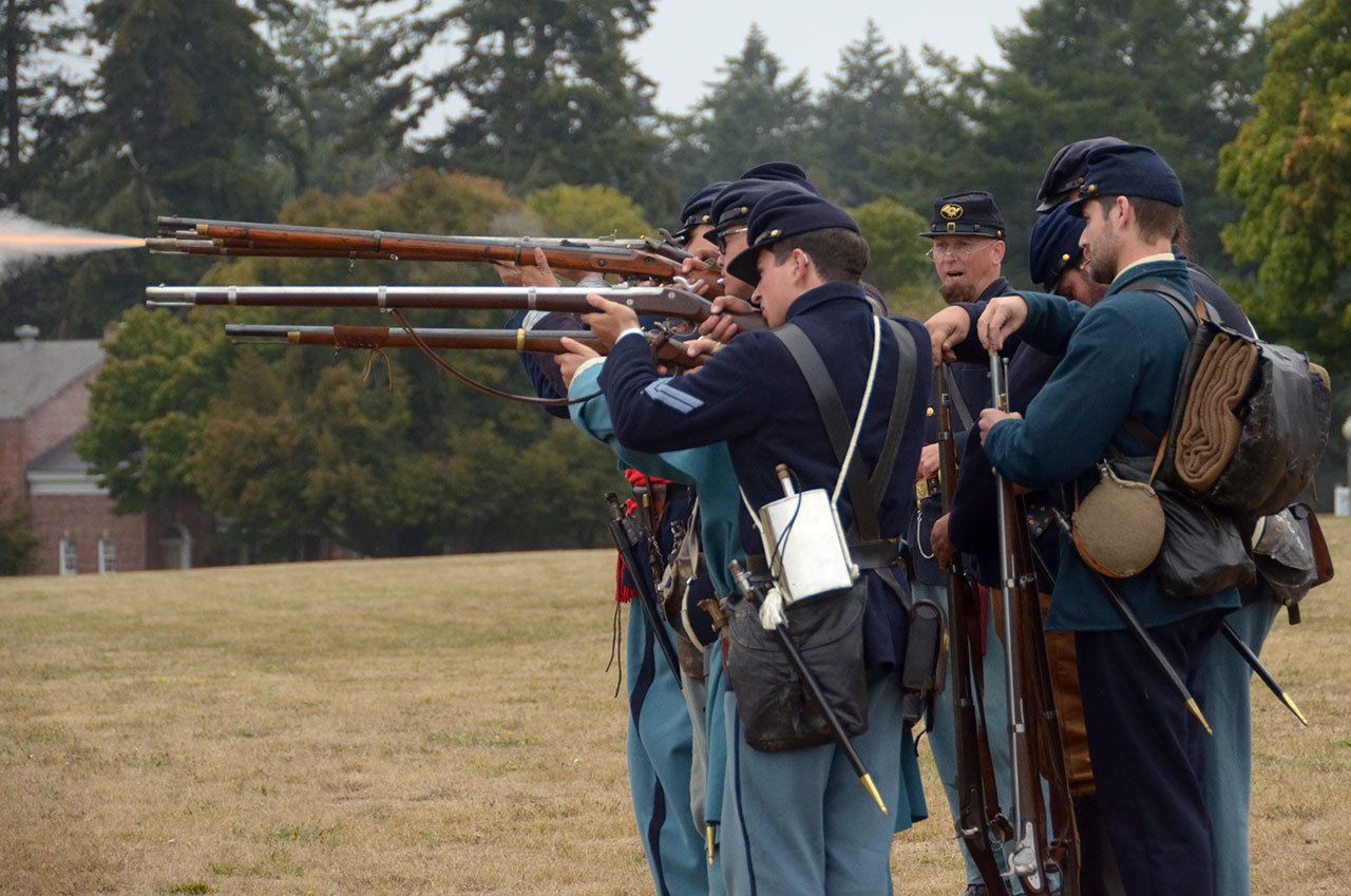 Cydney McFarland/Peninsula Daily News                                Members of the Company C 4th U.S. Infantry Civil War re-enactors group fire blank rounds on the field at Fort Worden during a performance Monday afternoon.