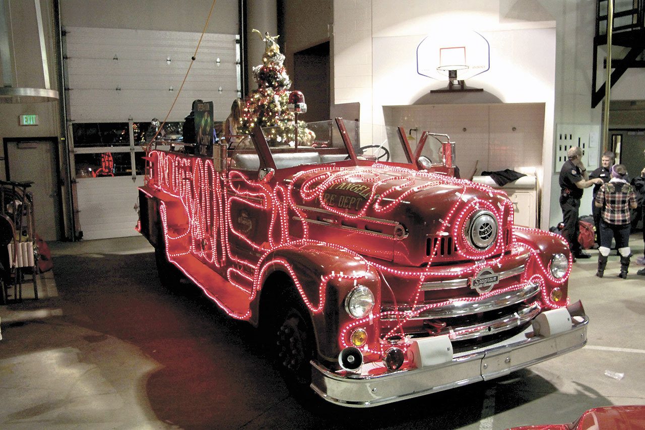 A vintage 1954 Seagrave fire engine is decked out in lights for Operation Candy Cane in December 2014. The Port Angeles City Council could approve the suprlus sale of the truck, known as Sparky, to the nonprofit Port Angeles Fire Department Auxiliary for $1 during its meeting today.(Dave Logan/for Peninsula Daily News)