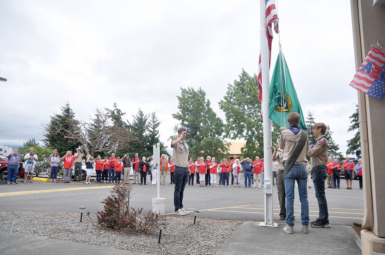 Sequim Boy Scout Troop 1498 raises the American and Washington state flag at the Sequim Elks Lodge on July 4. The troop, from left, Liam Stevenson, Devin Rynearson (foreground), Braven Headley and Dylan Washburn, presented colors at the Americans Helping Our Disabled Veterans and Their Families event, which was spearheaded by Sequim veteran Bill Ellis. (Michael Dashiell/Olympic Peninsula News Group)