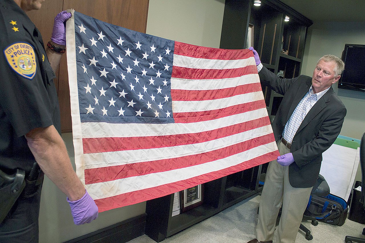 Everett Mayor Ray Stephanson, right, helps display a flag linked to a famous photo of Ground Zero in New York after the Sept. 11, 2001, terrorist attacks. The flag turned up in Everett in 2014 when an unidentified man dropped it off at a fire station. (City of Everett)