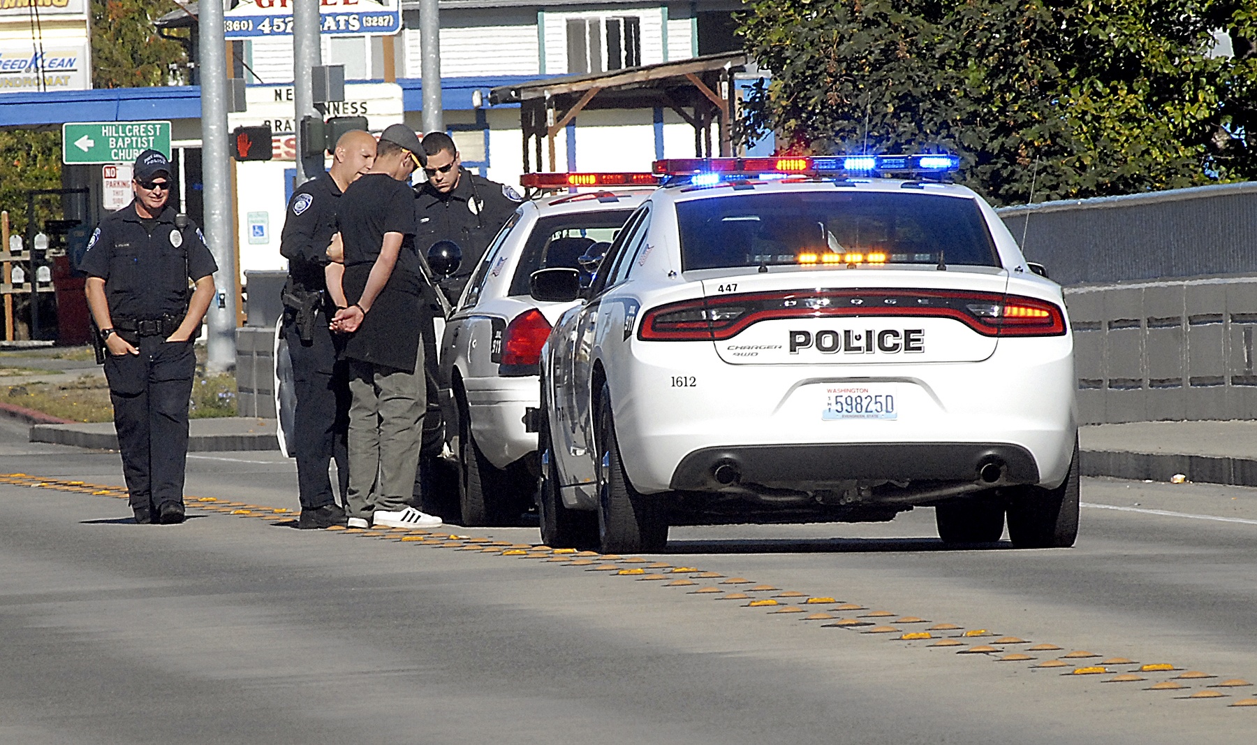 Port Angeles police take a man into custody on the Eighth Street bridge over Valley Creek on Tuesday. (Keith Thorpe/Peninsula Daily News)