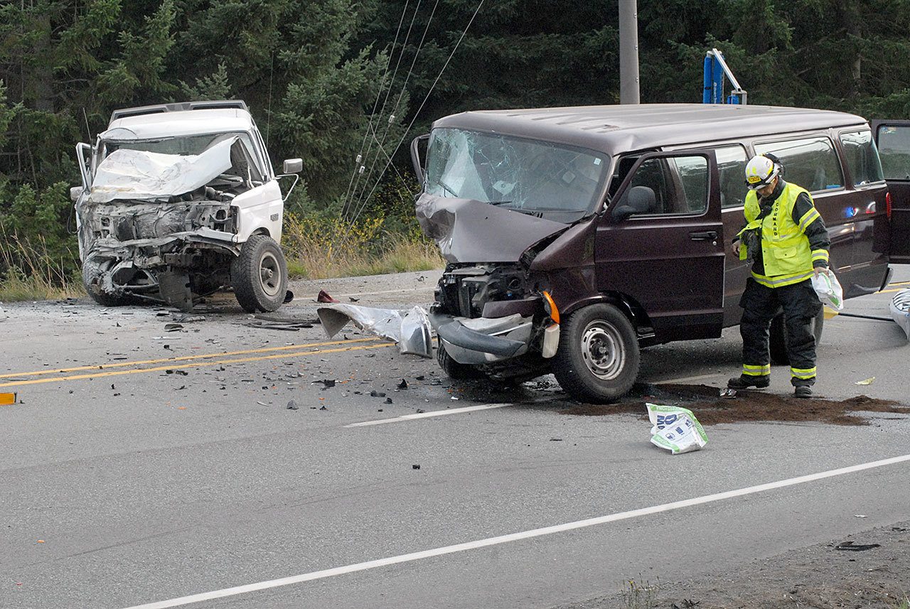 Dan Huff, assistant fire chief of Clallam County Fire District No. 2, spreads liquid absorbant at the scene of a multi-vehicle collision on U.S. Highway 101 west of Port Angeles that resulted in the death of former reality television personality Gabe Rygaard. (Keith Thorpe/Peninsula Daily News)