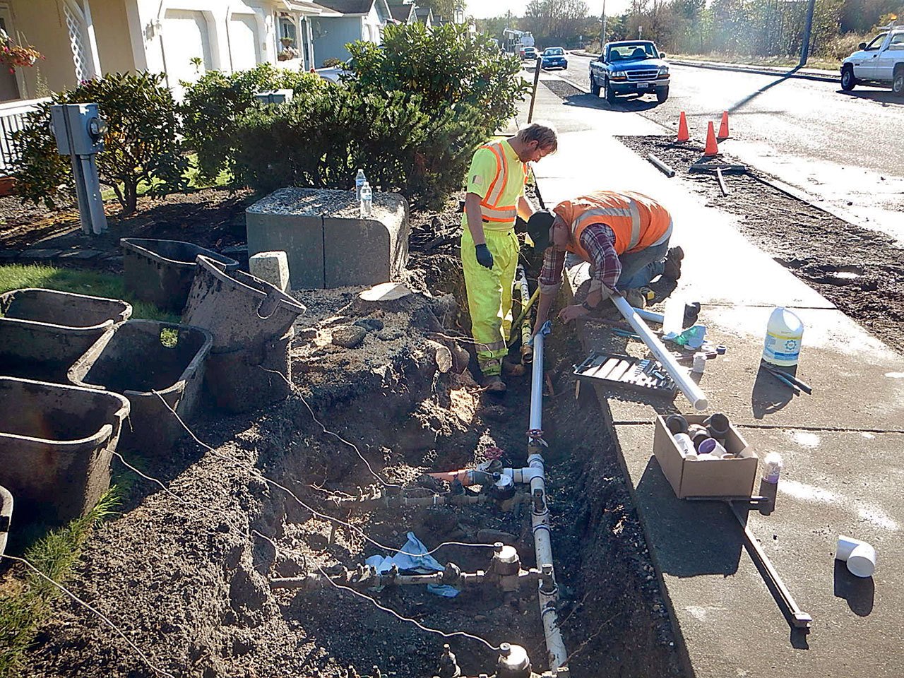 Jacob McBride, left, and Marty Hogoboom of the Sequim Public Works crew repair a water line break on the 800 Block of East Washington Place.
