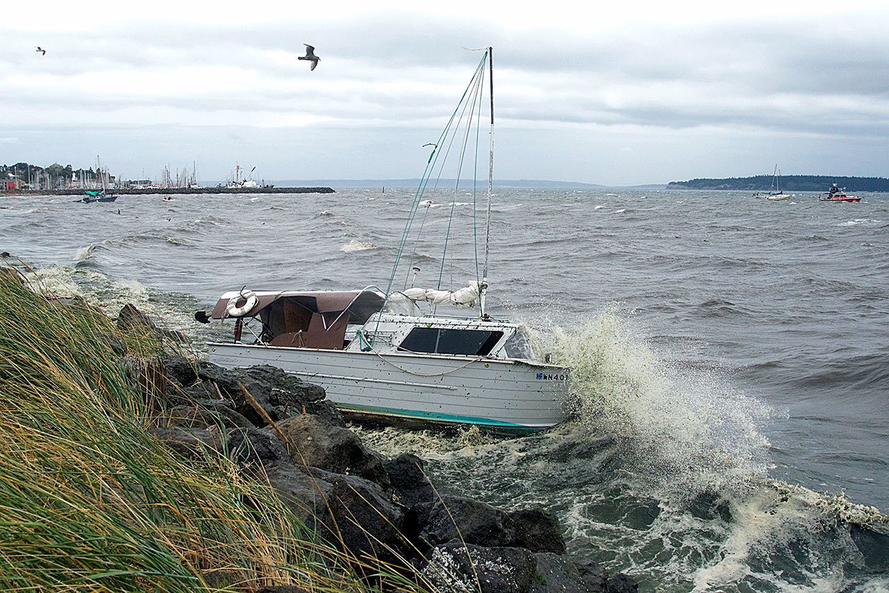 Steve Mullensky/for Peninsula Daily News                                The first storm of Autumn blows strong enough to cause a cabin cruiser, anchored in the south end of Port Townsend Bay, to slip its anchorage and dash against the rocks along the Larry Scott Trail in Port Townsend on Friday. In the background, a boat from Vessel Assist, right, helps tow another boat that was in danger of being grounded on the beach, to get to deeper water.                                The first storm of autumn blew strong enough to cause a cabin cruiser, anchored in the south end of Port Townsend Bay, to slip its anchorage and dash against the rocks along the Larry Scott Trail in Port Townsend on Friday. In the background, a boat from TowBoatUS, right, helps tow another boat that was in danger of being grounded on the beach. (Steve Mullensky/for Peninsula Daily News)