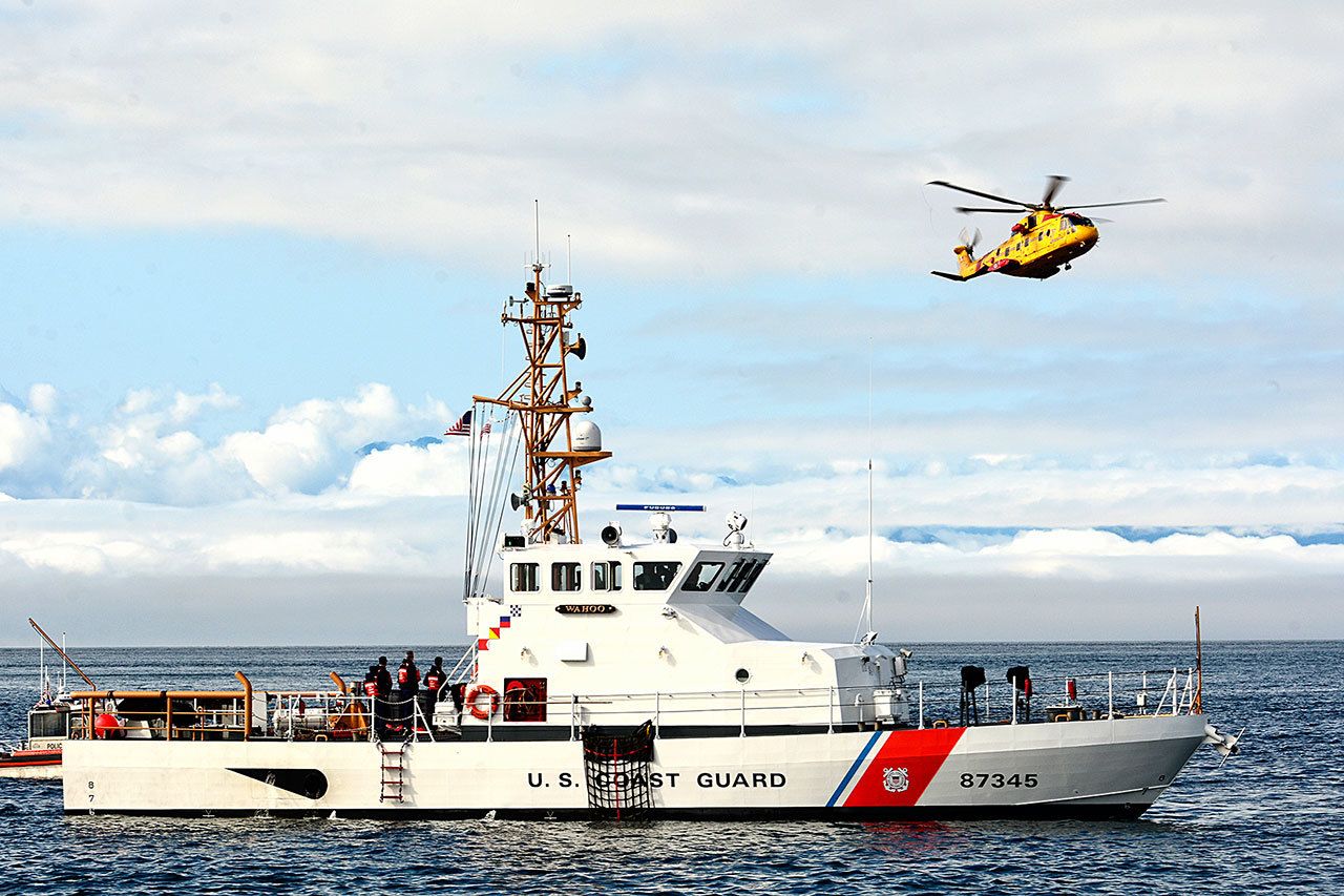 A Canadian helicopter passes behind the U.S. Coast Guard cutter Wahoo during an international mass-rescue drill in the Strait of Juan de Fuca on Tuesday. (Jesse Major/Peninsula Daily News)