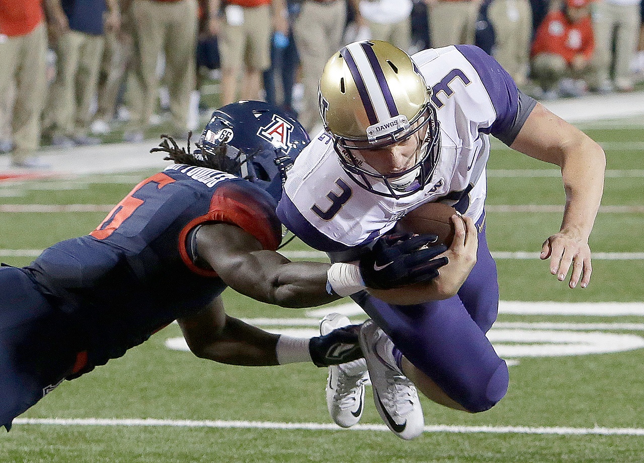 The Associated Press Washington quarterback Jake Browning (3) dives into the end zone with Arizona safety Demetrius Flannigan-Fowles hanging on during the Huskies 35-28 overtime victory over Arizona last Saturday.