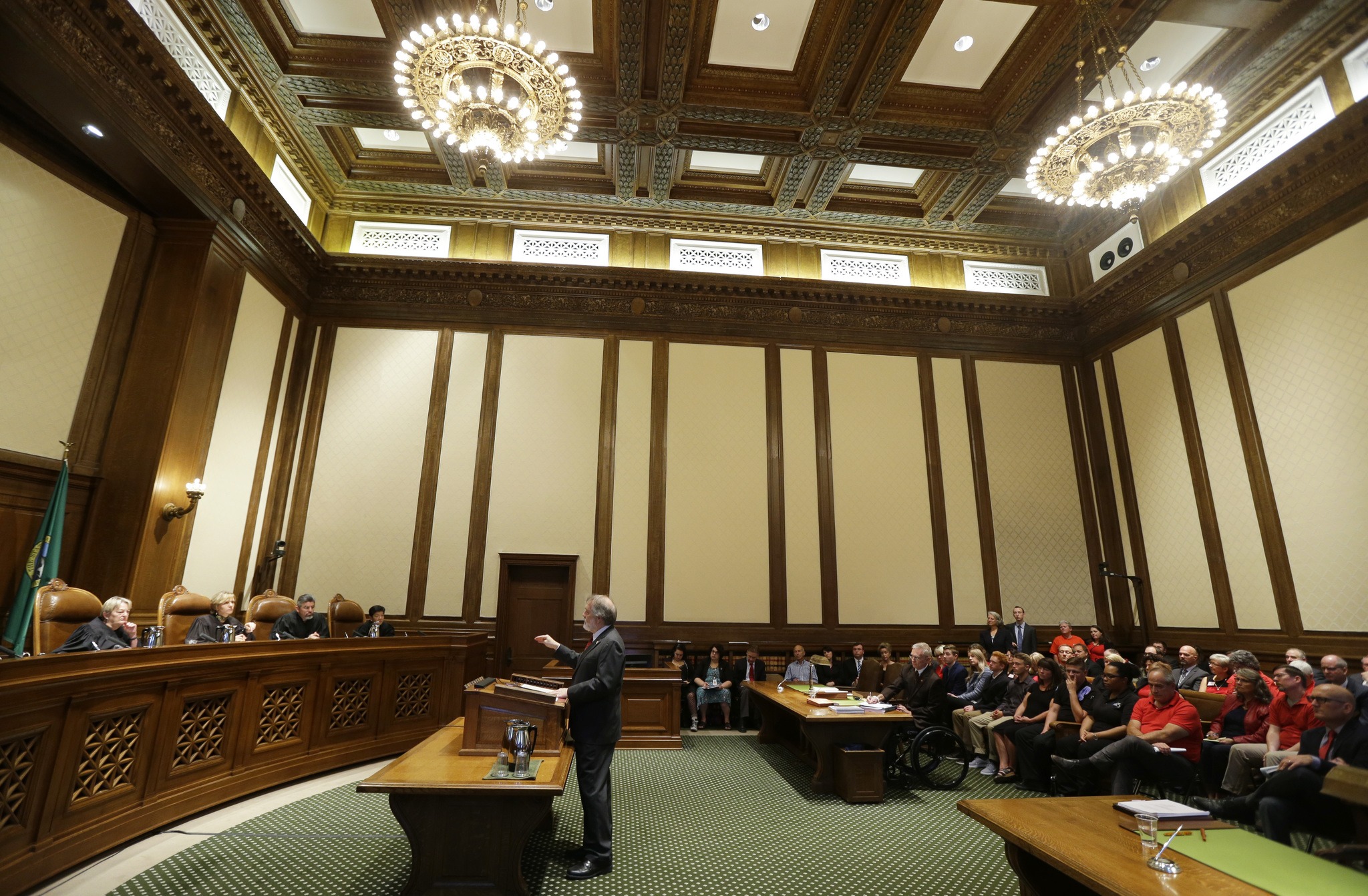 Alan Copsey, center, a deputy attorney general for the state of Washington, speaks during a hearing before the state Supreme Court regarding a lawsuit against the state over education funding on Wednesday in Olympia. (Ted S. Warren/The Associated Press)