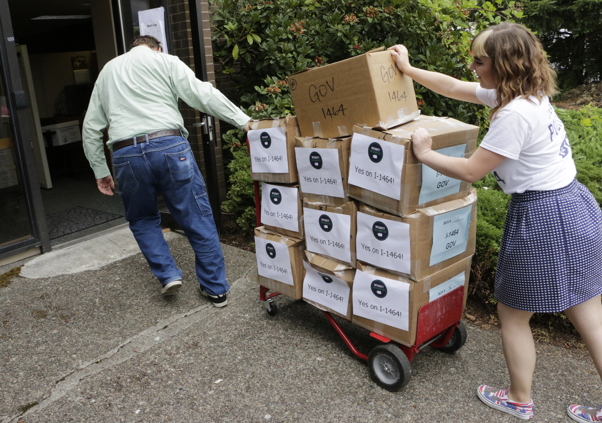 Supporters of a proposed campaign finance reform ballot measure arrive to turn in boxes of signed petitions in Olympia in July. (Rachel La Corte/The Associated Press)