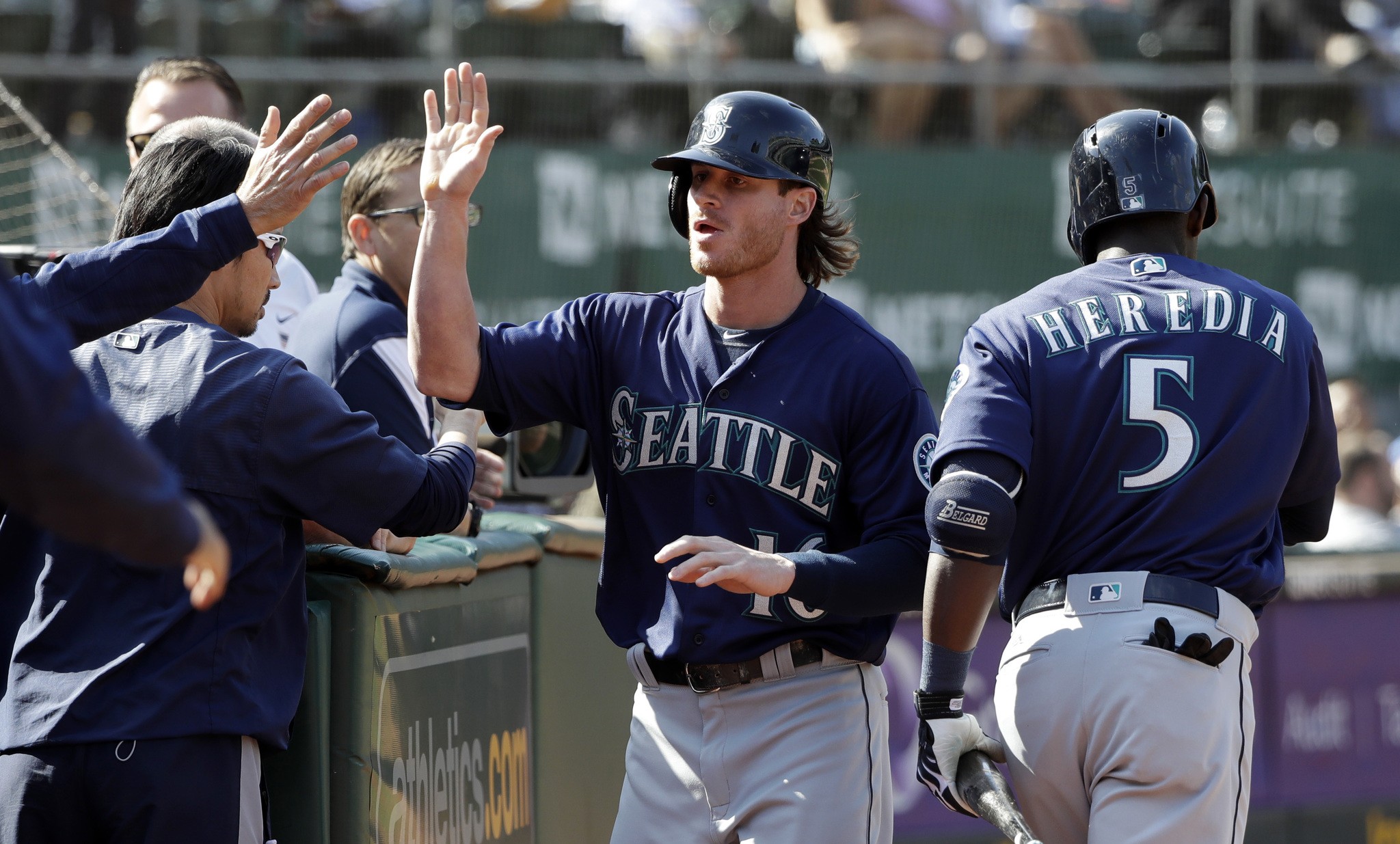 Seattle Mariners&rsquo; Ben Gamel, center, is high-fived in the dugout after scoring on a single by Ketel Marte during the ninth inning of a baseball game against the Oakland Athletics, Sunday, Sept. 11, 2016, in Oakland, Calif. (AP Photo/Marcio Jose Sanchez)