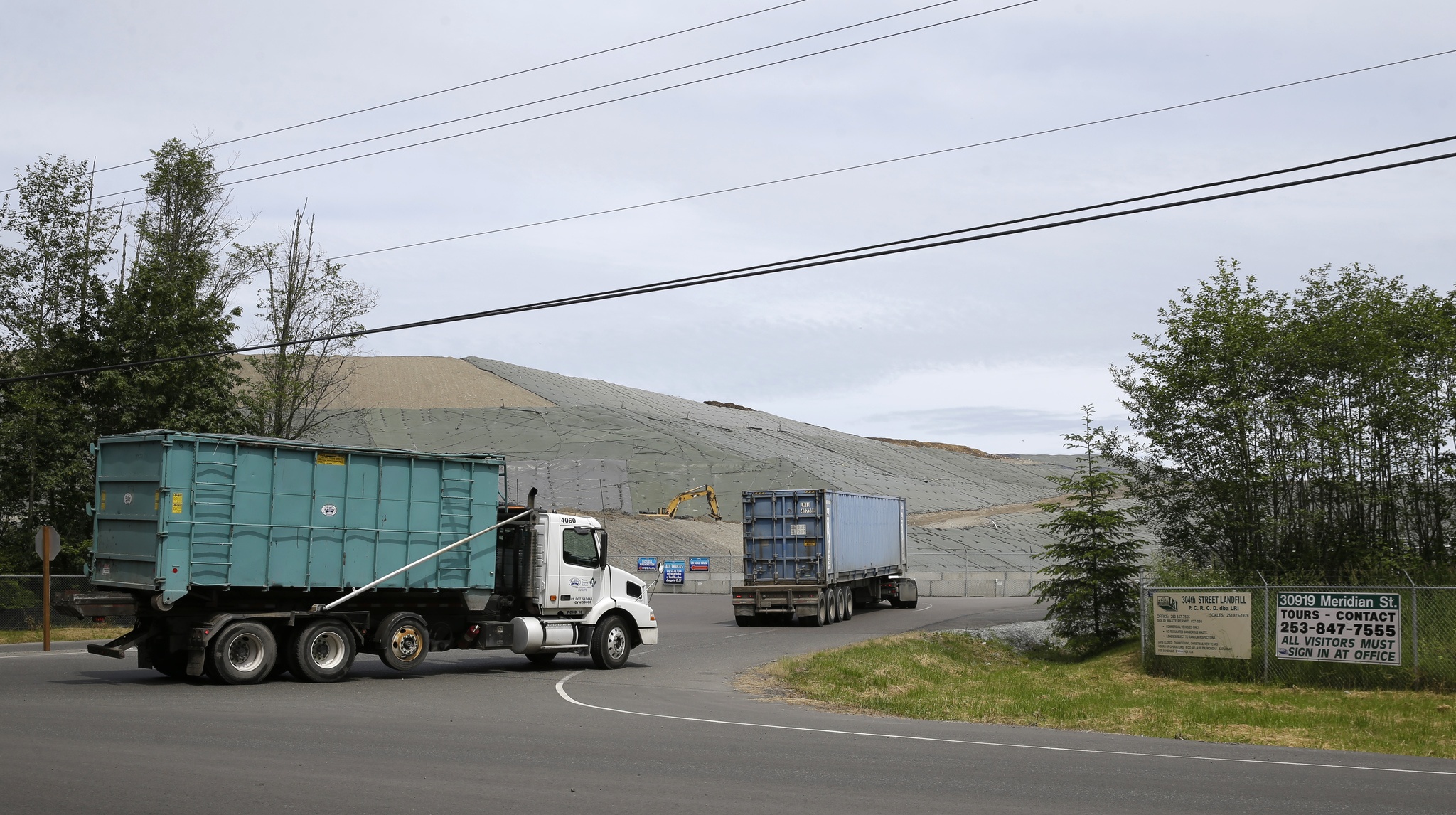 In this June 1 photo, trucks enter the LRI landfill in Graham. Washington state environmental regulators finalized a new rule Thursday to limit greenhouse gas emissions from large emitters, including the landfill. (Ted S. Warren/The Associated Press)