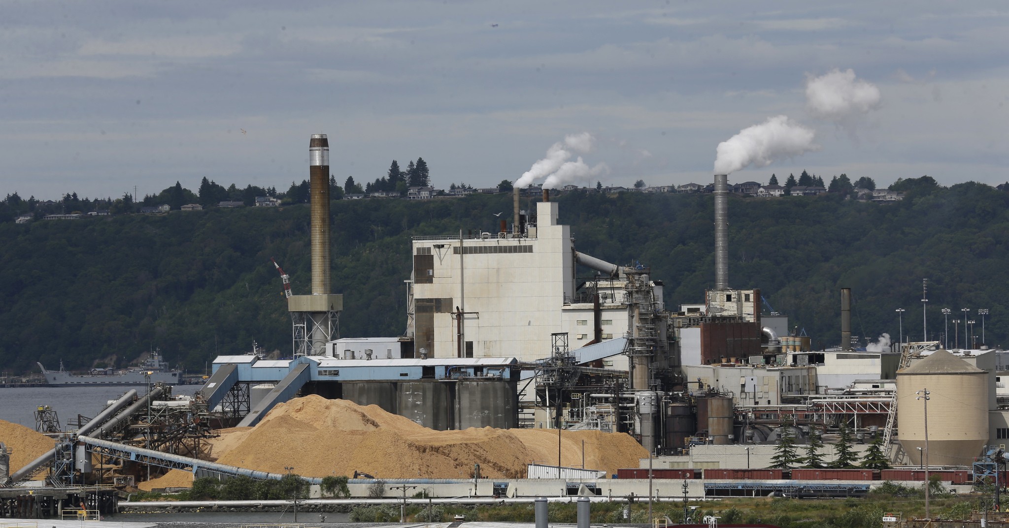 In this June 1 photo, piles of wood chips sit near the RockTenn paper mill in Tacoma. (Ted S. Warren/The Associated Press)