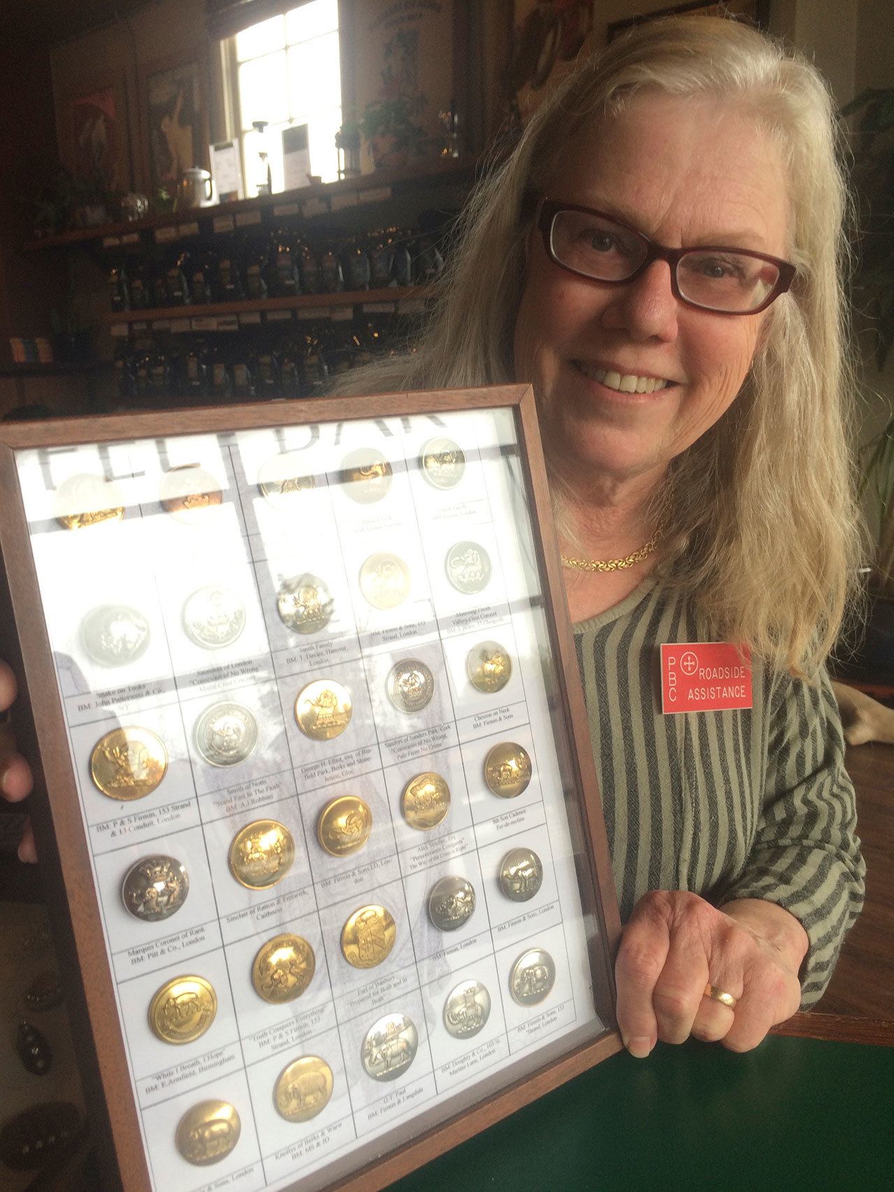 Gloria Skovronsky, president of the Peninsula Button Club, shows a shadow box display with buttons from her collection. The club is hosting the Washington State Button Society Convention and Show for the first time in Sequim today and Saturday. (Mary Powell)