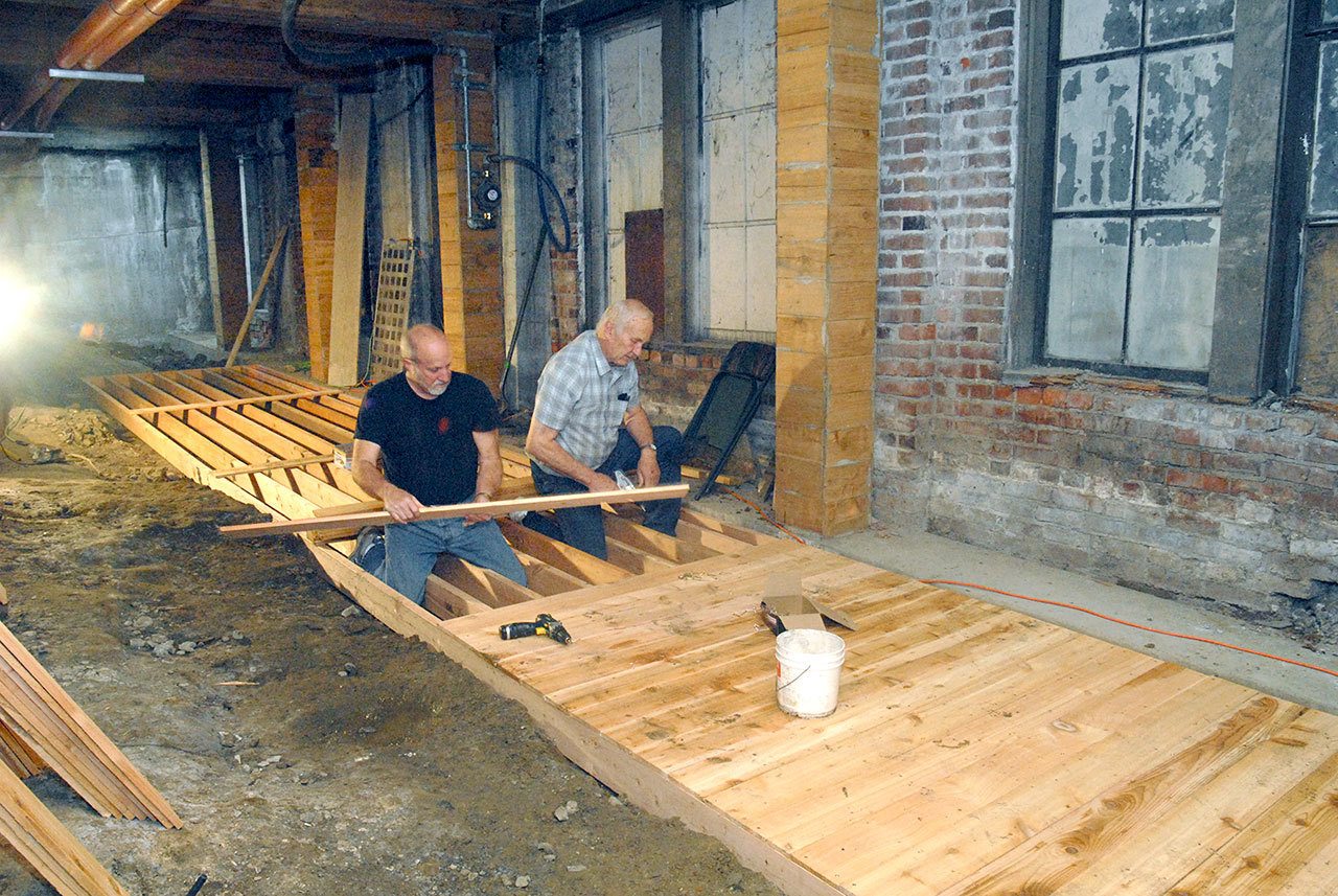 Don Perry, left, and Bill Huizinga install cedar planks last week for a walkway being built in the Port Angeles underground beneath the sidewalk on Laural Street in downtown Port Angeles. (Keith Thorpe/Peninsula Daily News)