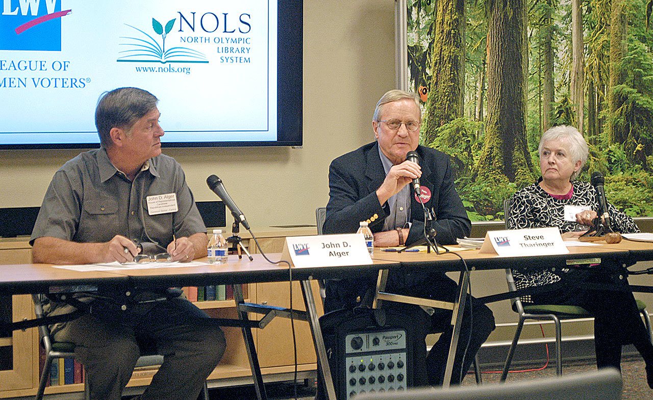 Incumbent Steve Tharinger, a Sequim Democrat, center, and John Alger, a Sequim Republican, square off during a League ofWomen Voters of Clallam County forum Thursday at the Port Angeles Library, discussing the McCleary decision, taxes and Planned Parenthood. Vicci Rudin, right, moderated the discussion. (Chris McDaniel/Peninsula Daily News)