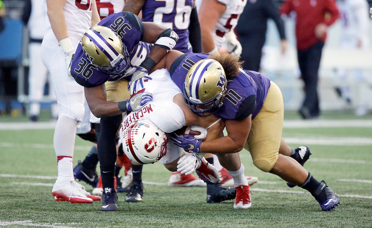 Stanford running back Christian McCaffrey (5) is tackled by Washington linebacker Azeem Victor (36) and defensive lineman Elijah Qualls in the first half of an NCAA college football game, Friday, Sept. 30, 2016, in Seattle. (AP Photo/Ted S. Warren)