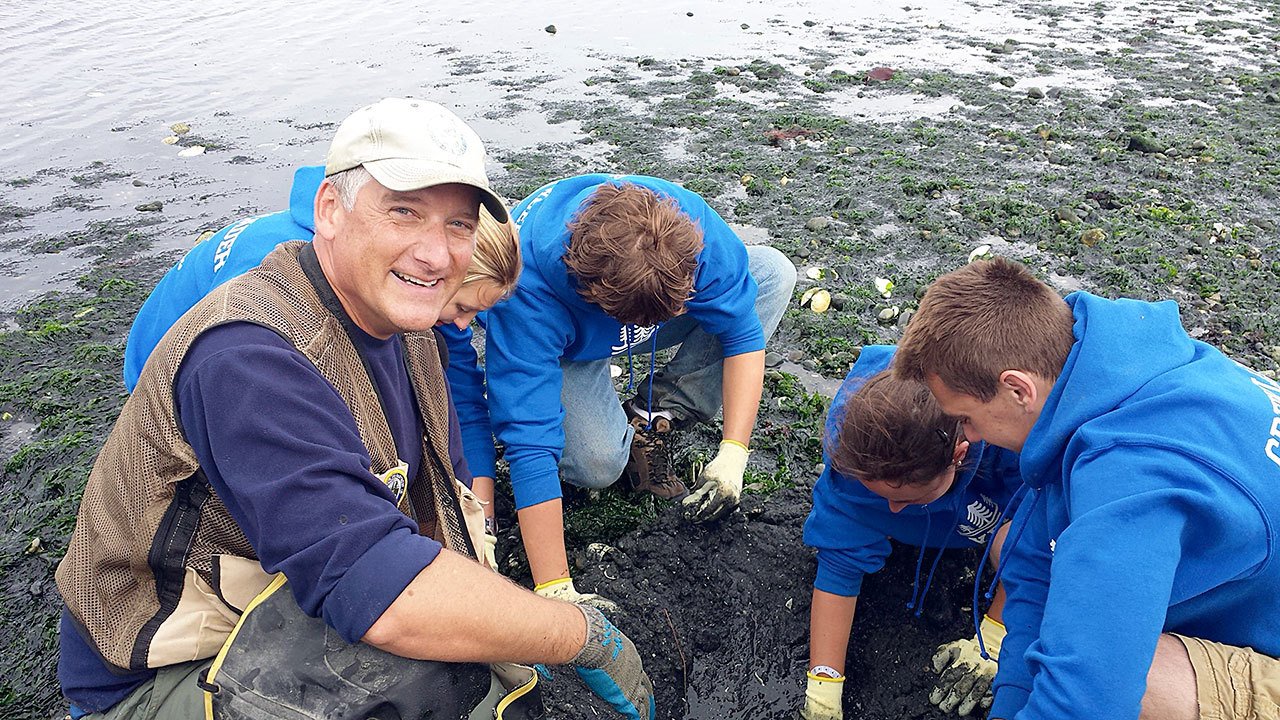 Paul Rogers of the state Department of Fish and Wildlife gets help from YES! students digging for shellfish for a Wooden Boat Festival display.