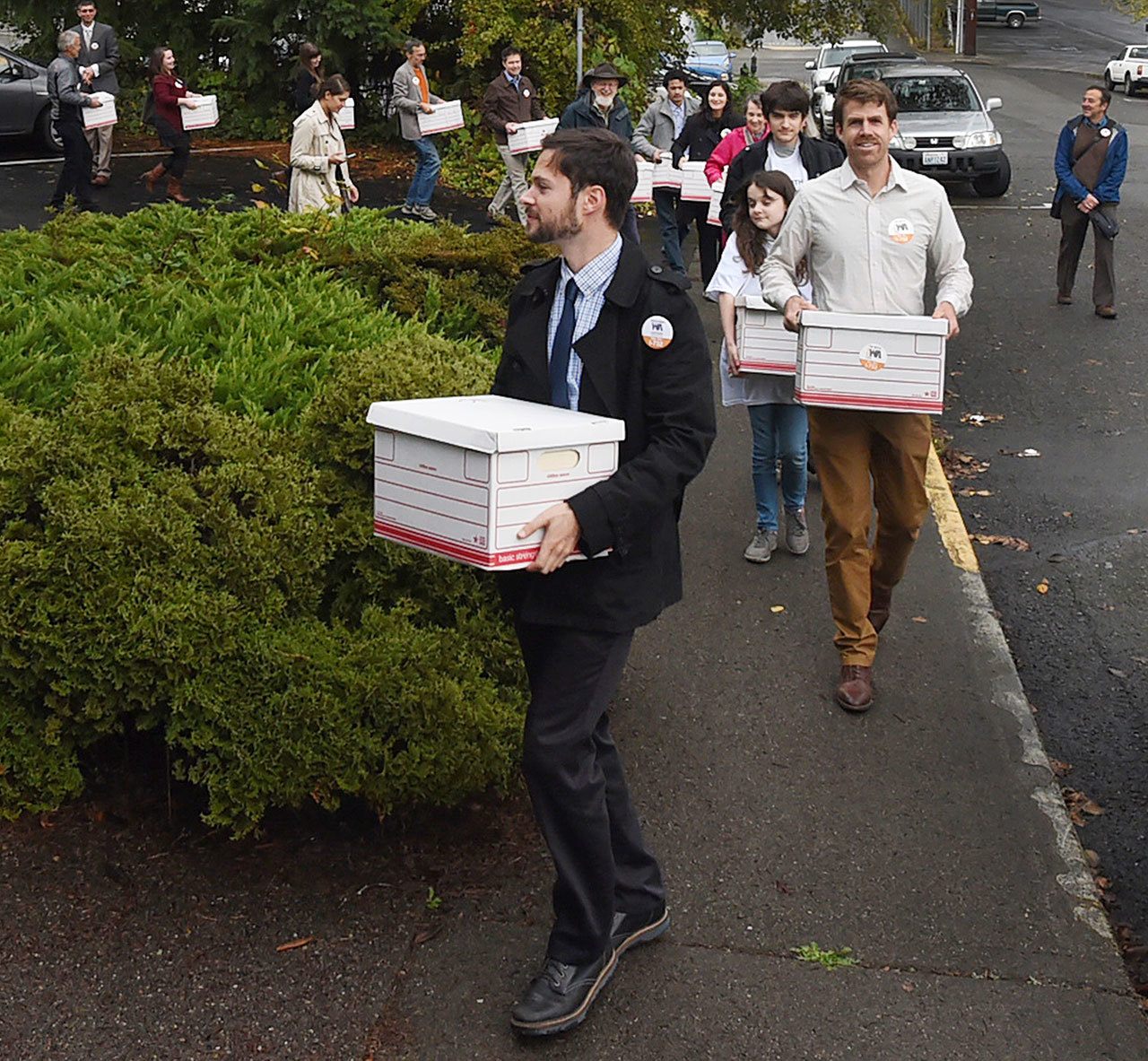 FILE - In this file photo taken Oct. 29, 2015, Carbon Washington campaign organizer Ben Silesky, left, leads a group of supporters and organization members into the Elections Office for the Washington Secretary of State in Olympia, Wash. to deliver signatures in support of putting Initiative 732 on the ballot. Voters in Washington state will weigh in on Initiative 732 in the 2016 election as they consider whether to approve the nation’s first direct carbon tax on the burning of fossil fuels. (Steve Bloom/The Olympian via AP, file)