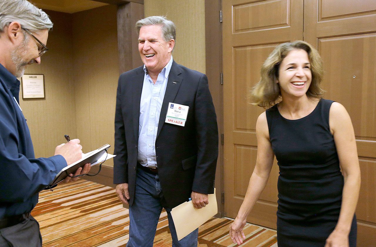 The Associated Press                                Democrat Hilary Franz, right, and Republican Steve McLaughlin, center, laugh Sept. 14 after McLaughlin won a coin toss made by Jason Hagey, left, vice president of Communications for the Association of Washington Business, before the two debated at the AWB Policy Summit in Cle Elum.