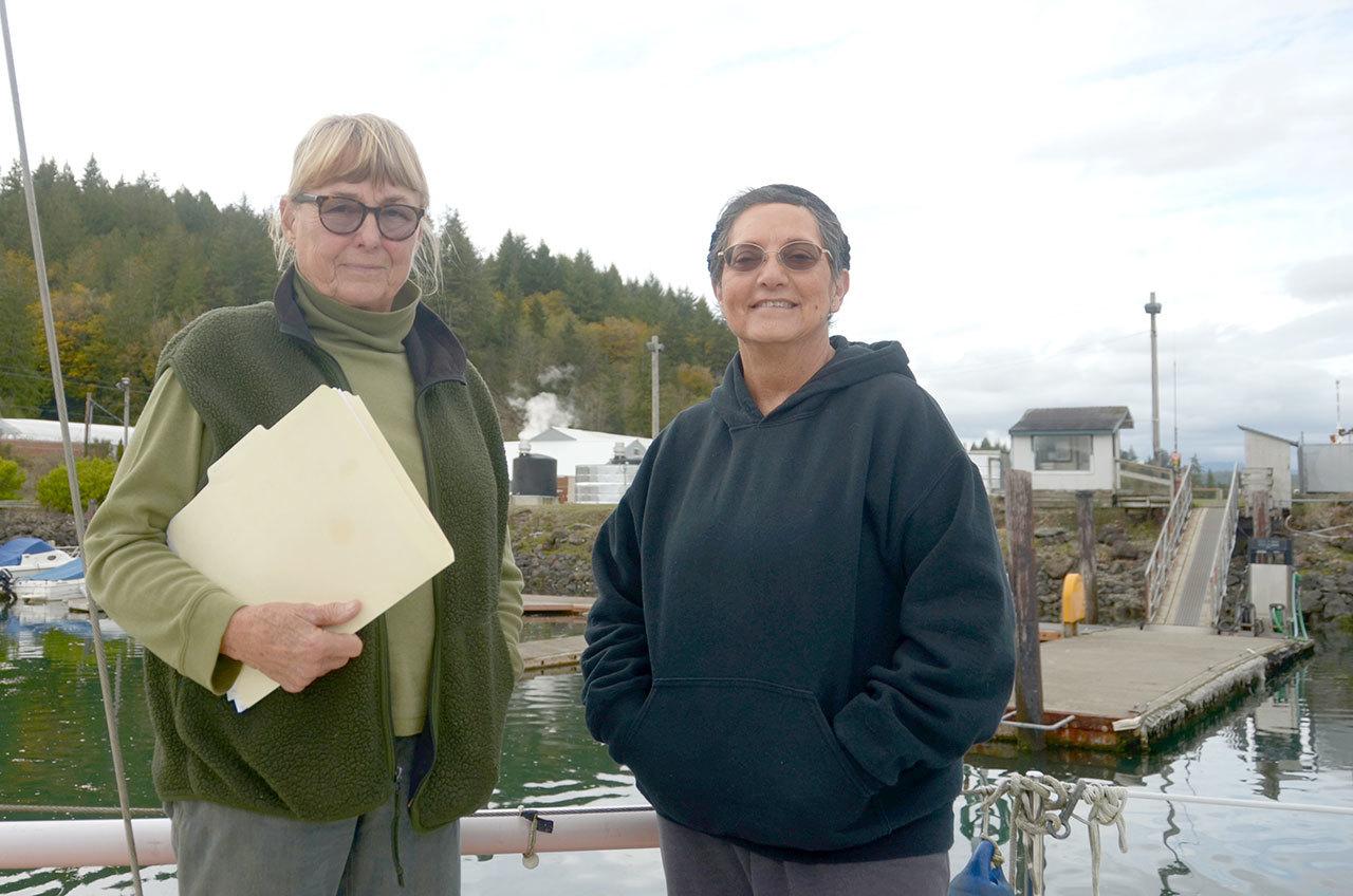 Anne Ricker, left, and Connie Gallant stand on Gallant’s boat in Quilcene Marina. They are two of the community members that have been vocal about their opposition to any Port of Port Townsend plan that could limit public access to the marina and the beach next to it. (Cydney McFarland/Peninsula Daily News)