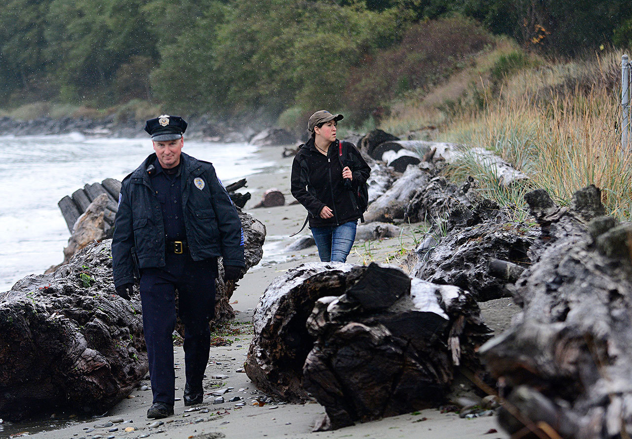 Sgt. Jason Viada of the Port Angeles Police Department and Viola Ware, program director of coordinated intake for Serenity House, walk the Port Angeles waterfront looking for people who may need to use Serenity House’s shelter. (Jesse Major/Peninsula Daily News)