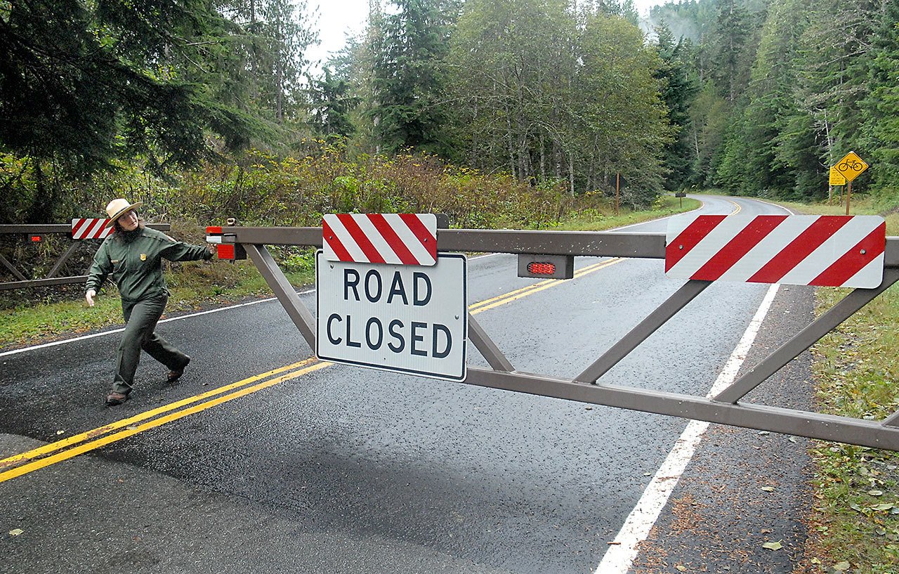 Amy Mattix, a visitor use assistant for Olympic National Park, closes the gate on the road to Hurricane Ridge on Thursday after officials decided to close portions of the park in anticipation of a series of storms approaching the North Olympic Peninsula. (Keith Thorpe/Peninsula Daily News)
