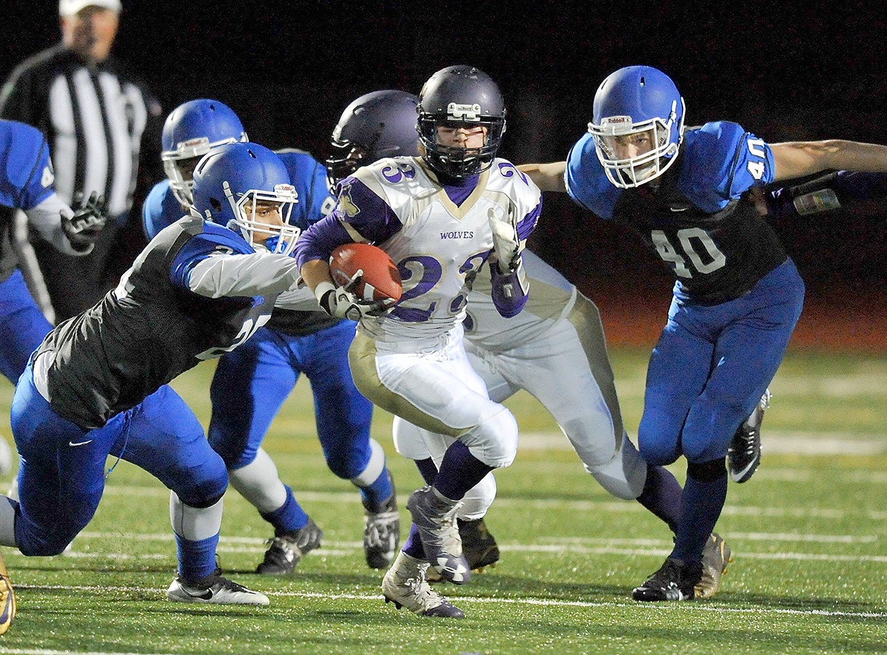Sequim Wolves running back Gavin Velarde (23) breaks free for a big gain in a game against Olympic HS. Defenders on the play Scott Ashcraft (25) and Jayce Holcomb (40).