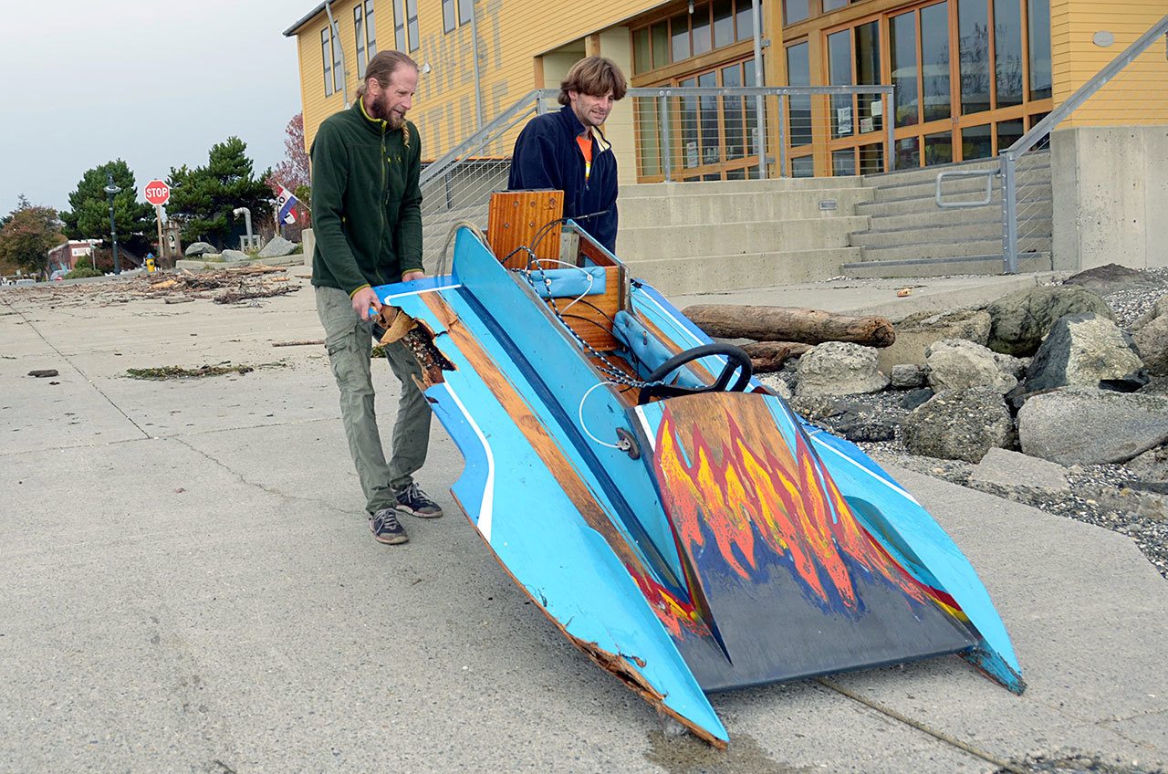 Ben Justice, left, and his friend Donny Regan pull Justice’s battered boat up the boat ramp next to the Northwest Maritime Center in Port Townsend. (Cydney McFarland/Peninsula Daily News)