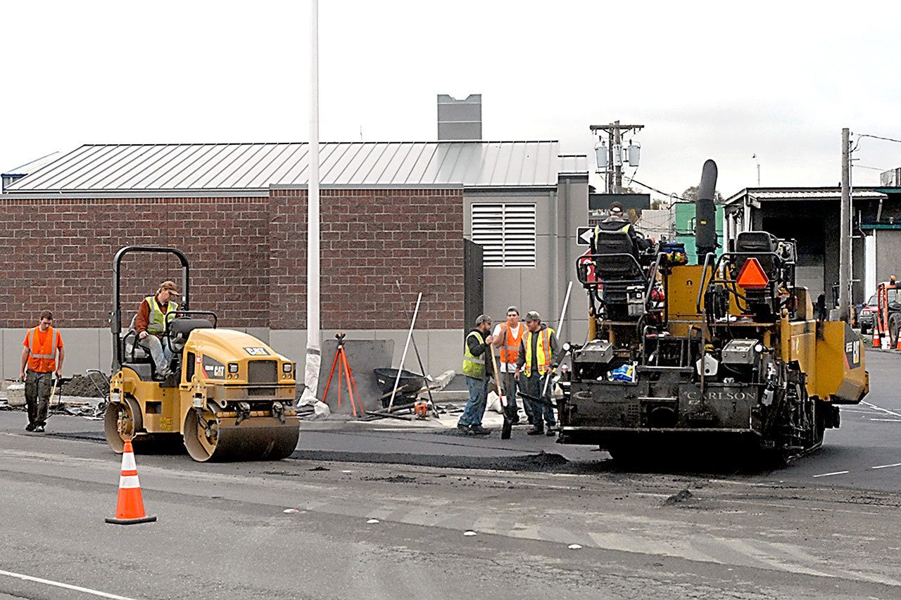 A paving crew from Lakeside Industries installs asphalt Wednesday at the alley access to a new wastewater pump station along Marine Drive in Port Angeles. (Keith Thorpe/Peninsula Daily News)