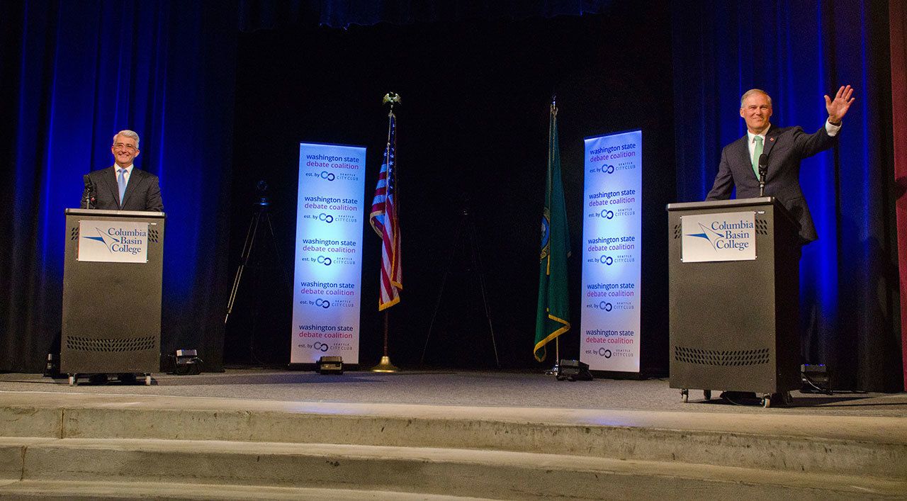 Republican candidate Bill Bryant, left, and Democratic Gov. Jay Inslee take the stage at Columbia Basin College in Pasco on Wednesday night for their gubernatorial debate. (Greg Lehman/Walla Walla Union-Bulletin via AP)