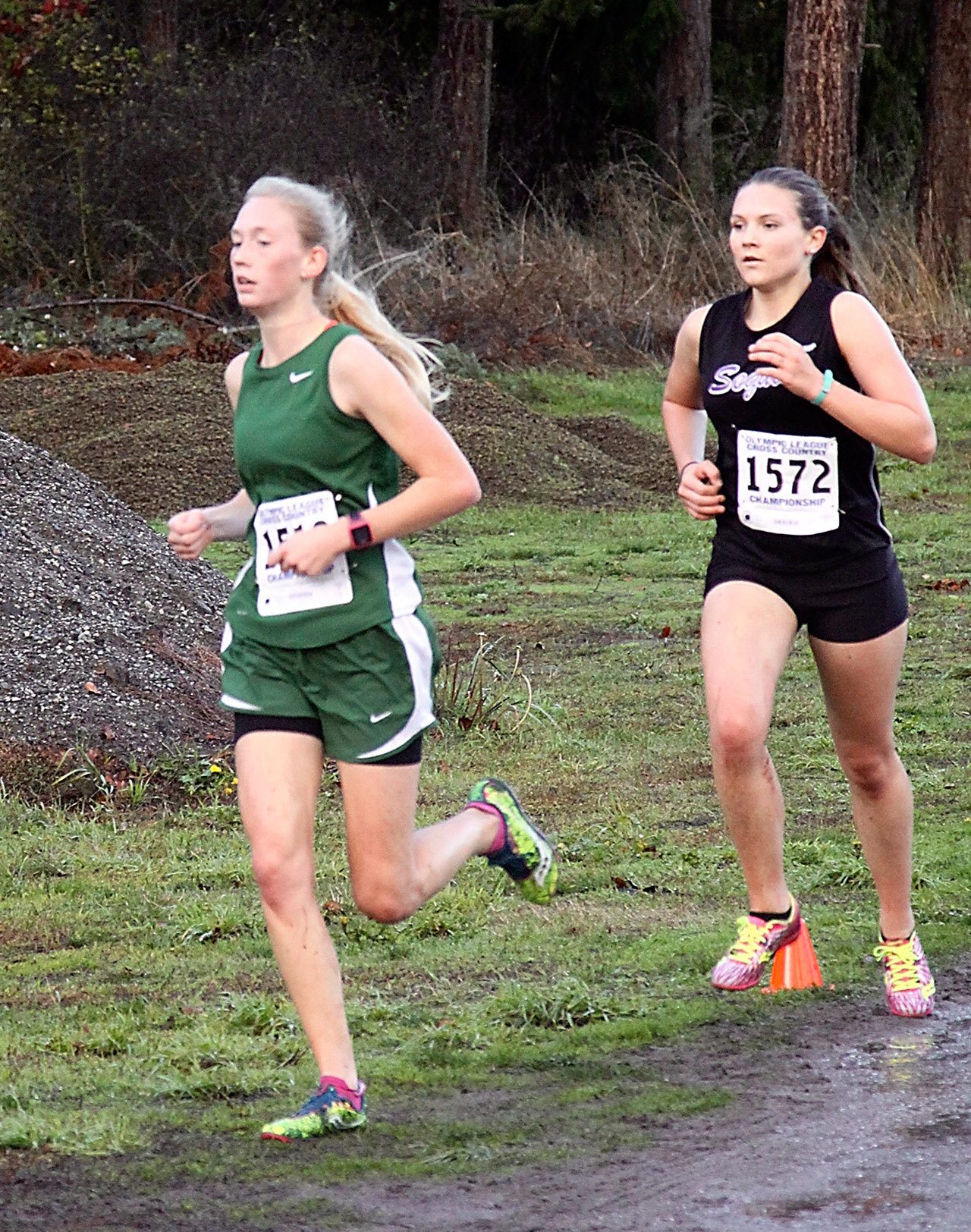 Dave Logan/For Peninsula Daily News                                Port Angeles&rsquo; Gracie Long, left, won the Olympic League girls cross country title while Sequim&rsquo;s Morgan Bingham finished second. The Roughriders claimed the team title as well.