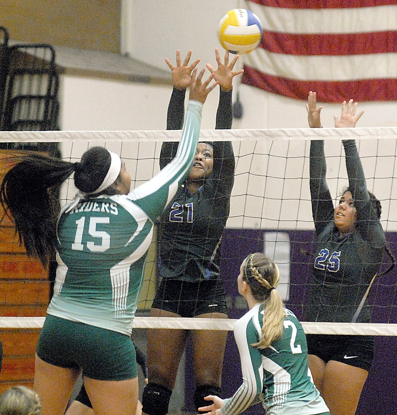 Keith Thorpe/Peninsula Daily News Port Angeles’ Nizhoni Wheeler, left, tips the ball across the net as Sequim’s Adrienne Haggerty and Kaila Sundquist try to block during the second game of their match on Thursday night in Sequim. Looking on at the net was Port Angeles’ Callie Hall.