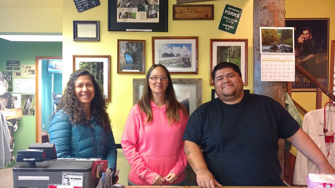 From left, Sandy Taylor, a visitor from Sequim, stands with Lee Hunter and Phil Sifuentes of the Forks Visitors Center. (Zorina Barker/for Peninsula Daily News)