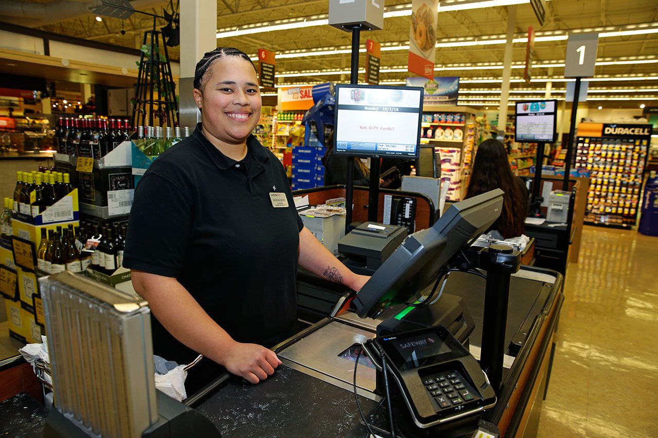 Ariana Davis is seen at the Safeway store where she works in Renton earlier this month. Davis is the sponsor of Initiative 1433. (Ted S. Warren/The Associated Press)