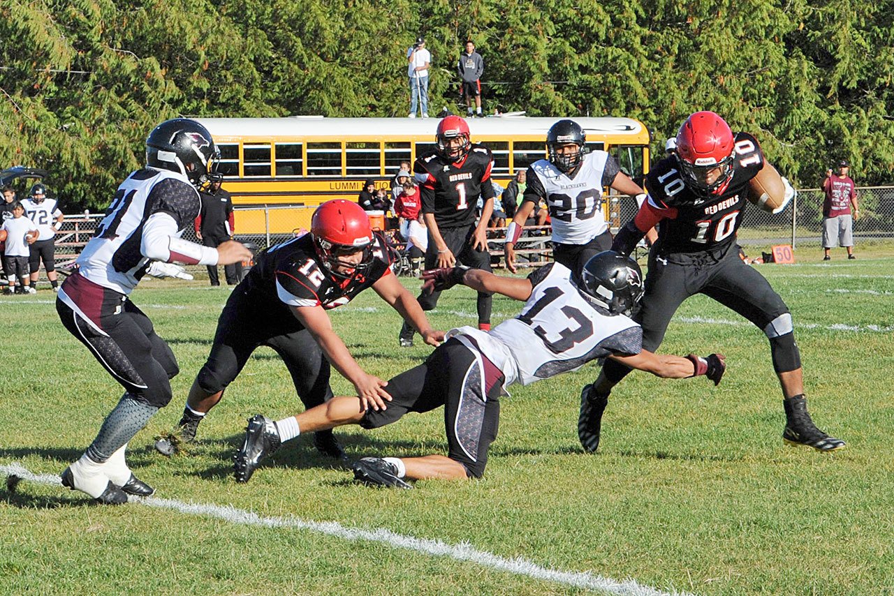 Lonnie Archibald/for Peninsula Daily News Neah Bay’s Rwehabura Munyagi (10) avoids Lummi’s Raven Borsey (13) in Neah Bay’s game against Lummi in September. Also in on the play from Neah Bay are from left, Caleb Revey (21) Phillip Greene (12).