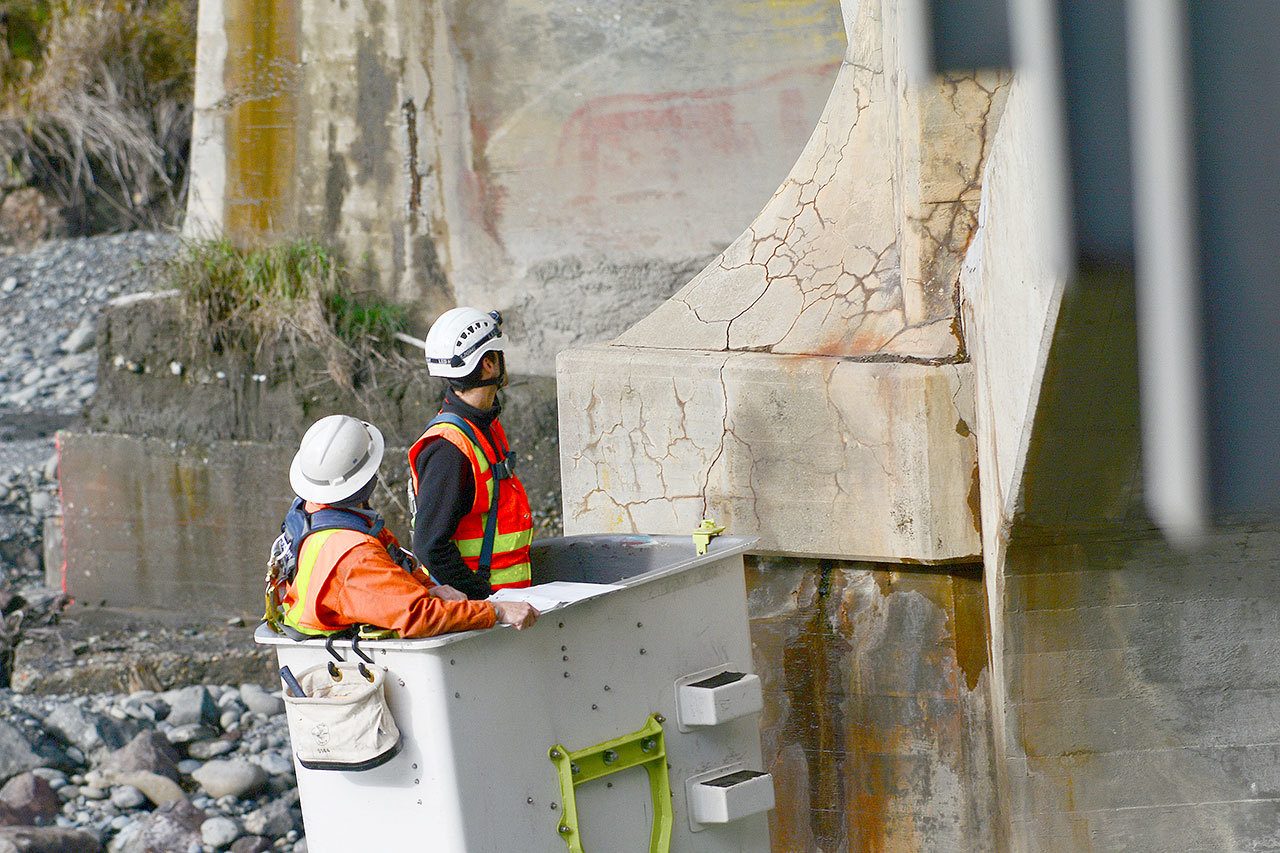 State Department of Transportation crews work Tuesday to inspect cracks in the Elwha River bridge on U.S. Highway 101 west of Port Angeles and to install crack monitors. (Jesse Major/Peninsula Daily News)