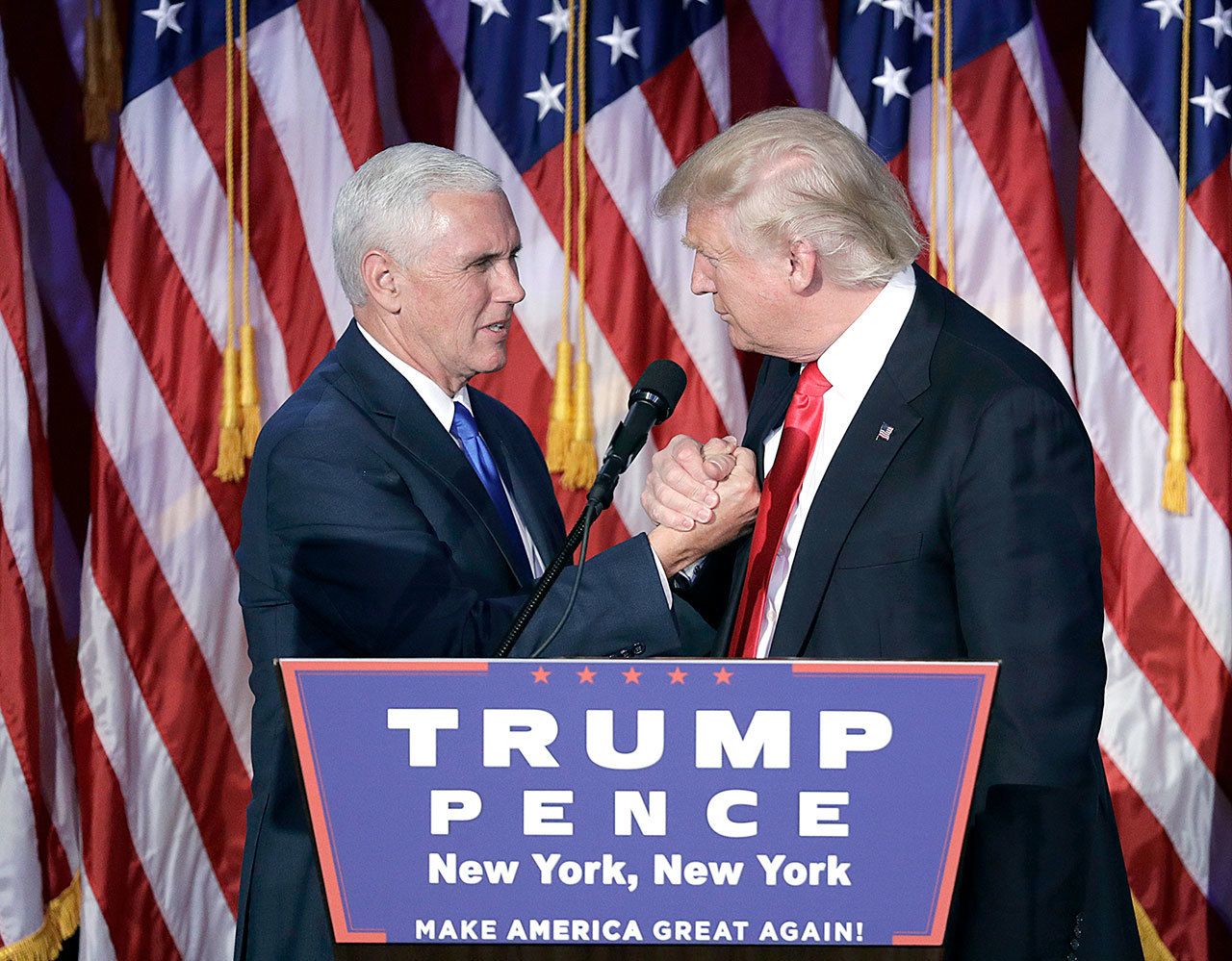 President-elect Donald Trump shakes hands with Vice President-elect Mike Pence as he gives his acceptance speech during his election night rally in New York City. (John Locher/The Associated Press)
