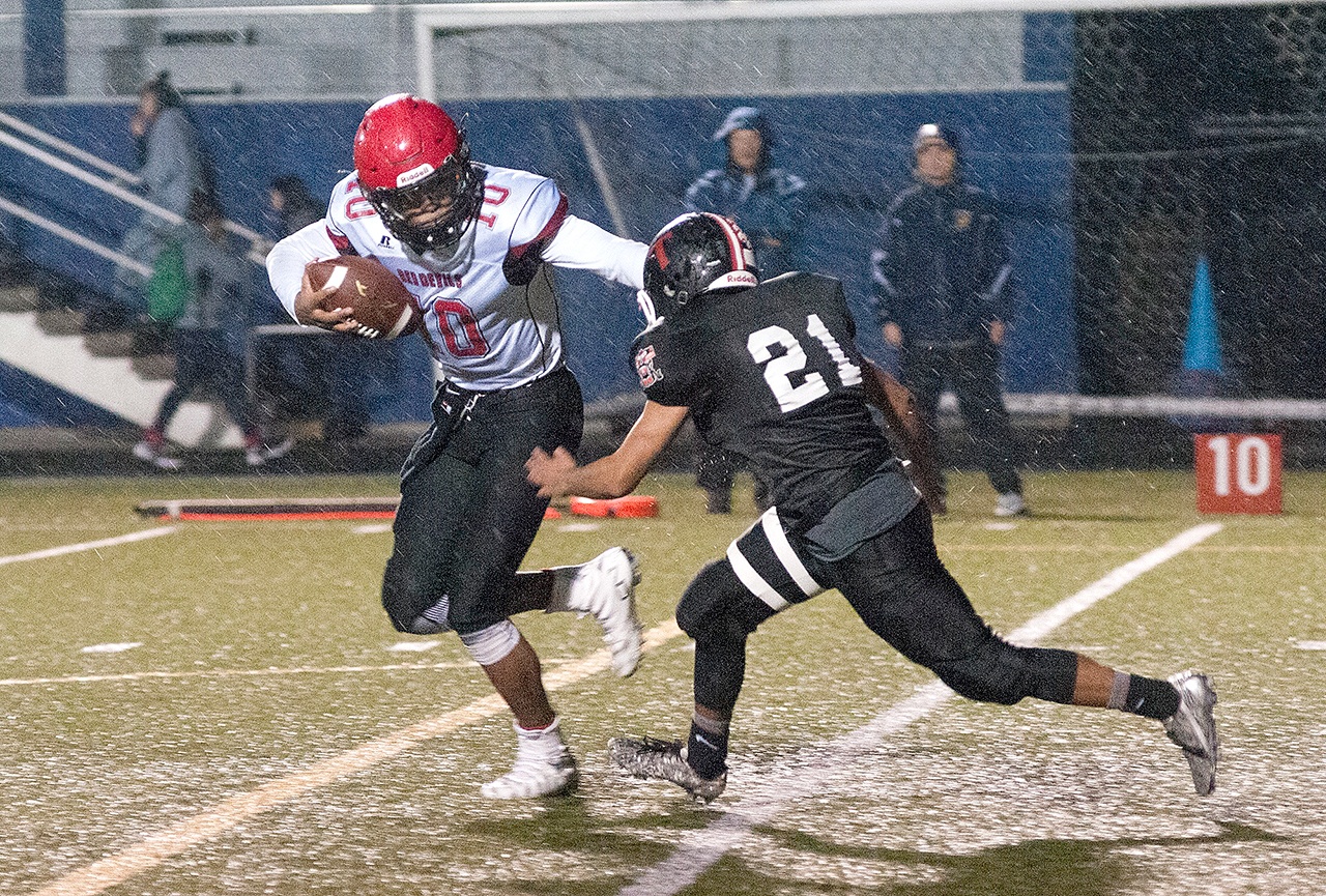 The Daily World Neah Bay’s Rwehabura Munyagi Jr. fends off the defense of Taholah’s Brett Orozco during the Red Devils’ 58-22 win over the Chitwins at Stewart Field in Aberdeen.
