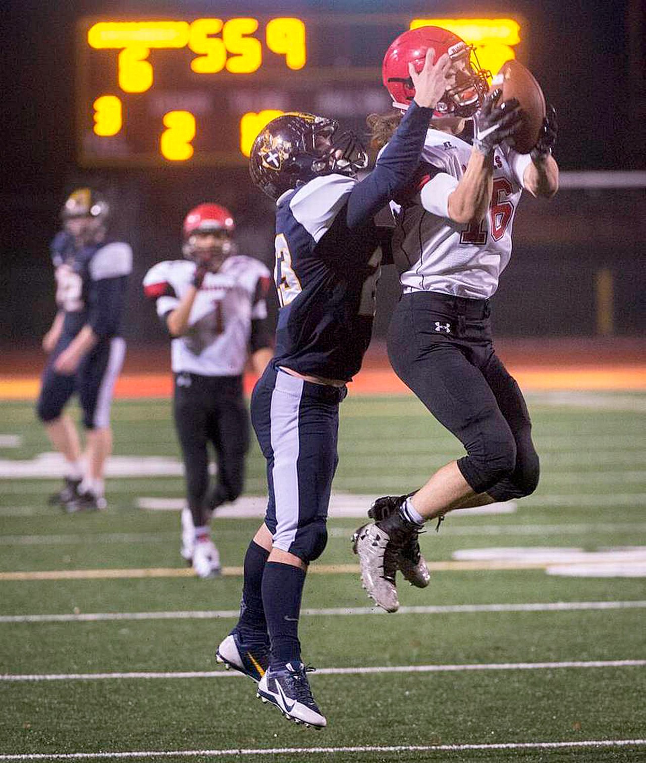 McClatchy News Service Neah Bay’s Cole Svec intercepts a pass in front of Tacoma Baptist receiver Doug Stone near the end of the first half of the Red Devils’ 66-26 victory.