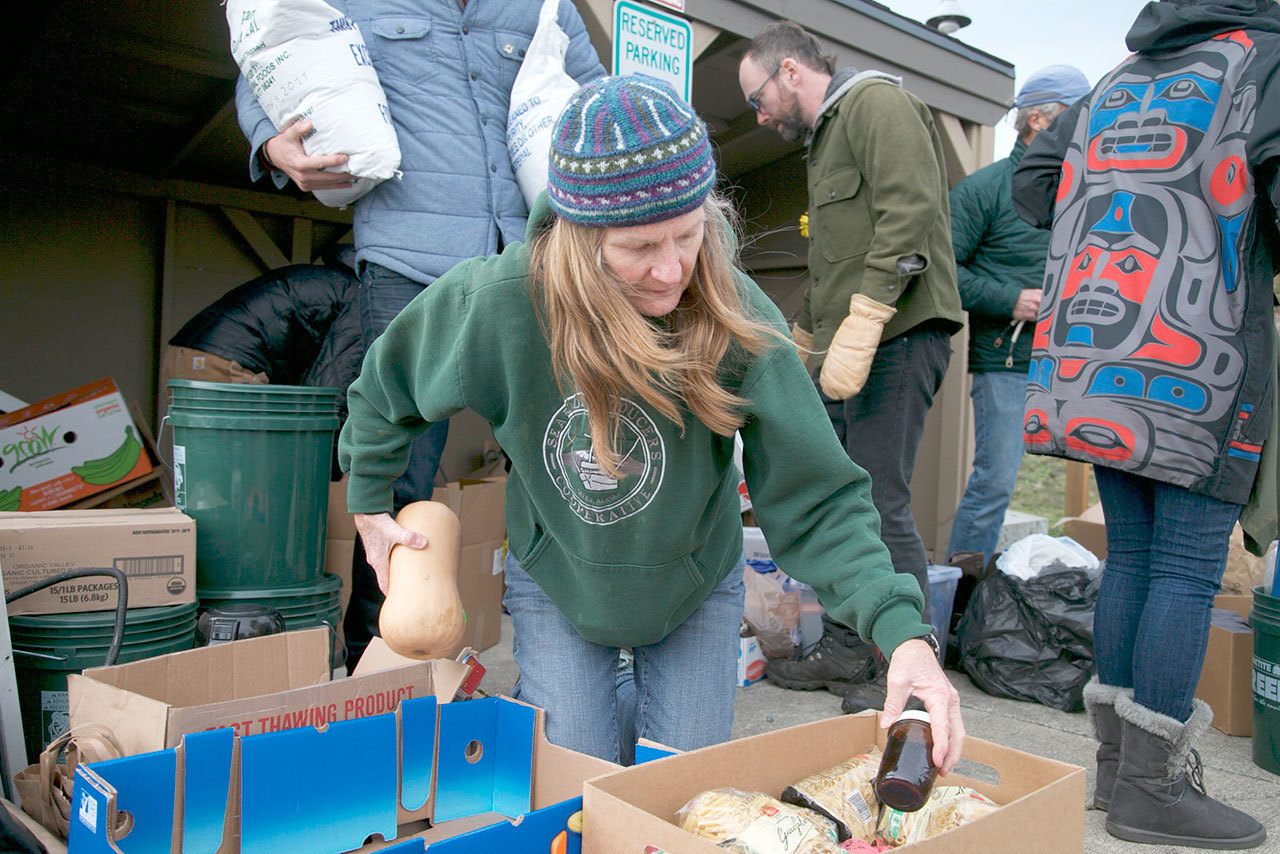 Candice Cofler, from Port Townsend and a volunteer with Standing Rock Thanksgiving Caravan, sorts groceries Sunday destined for the pipeline protesters in Standing Rock. (Steve Mullensky/for Peninsula Daily News)