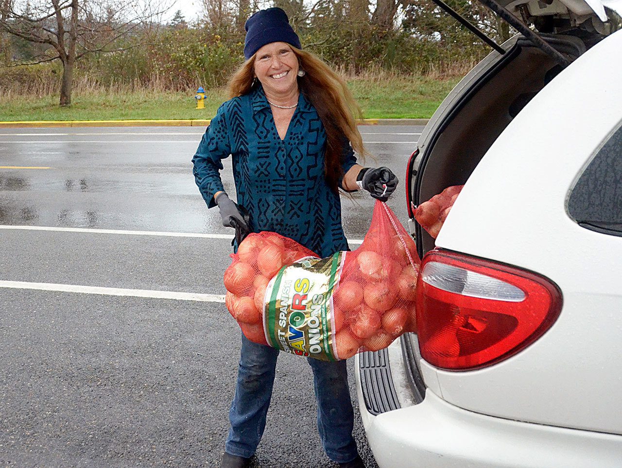 Shirley Moss, manager of the Jefferson County Food Bank, unloads a donation of onions Tuesday in preparation for the busy Thanksgiving holiday. (Cydney McFarland/Peninsula Daily News)