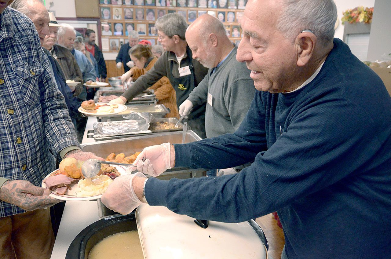 Volunteer Jim Simcoe of Port Townsend ladles gravy at the Thanksgiving meal at the Tri-Area Community Center in Chimacum. (Cydney McFarland/Peninsula Daily News)