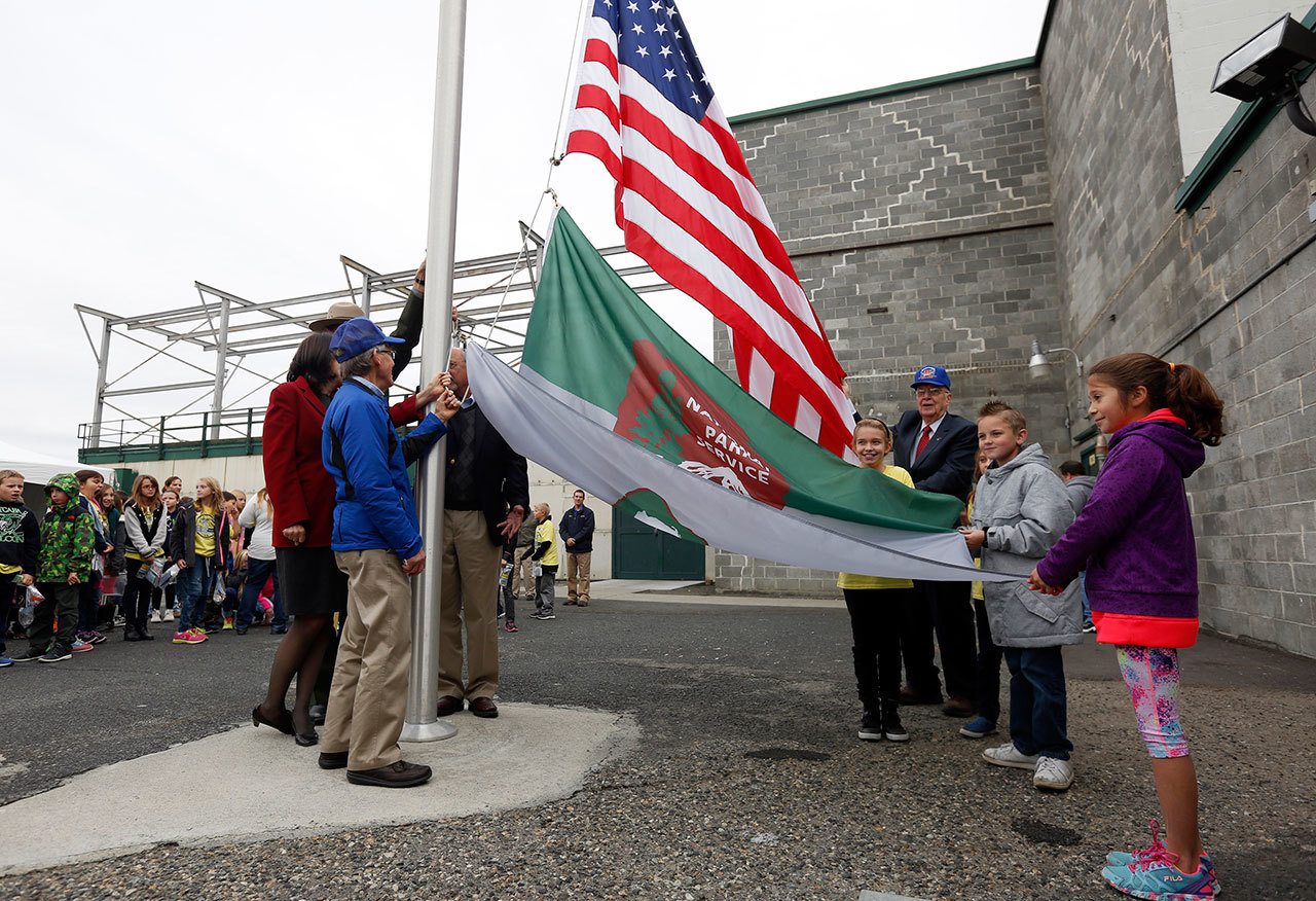 Fourth-grade students from White Bluffs Elementary School on Nov. 12, 2015, help local historians and politicians raise the National Parks Service flag for the first time at Hanford’s B Reactor, near Richland. (Sarah Gordon/The Tri-City Herald via AP, File)